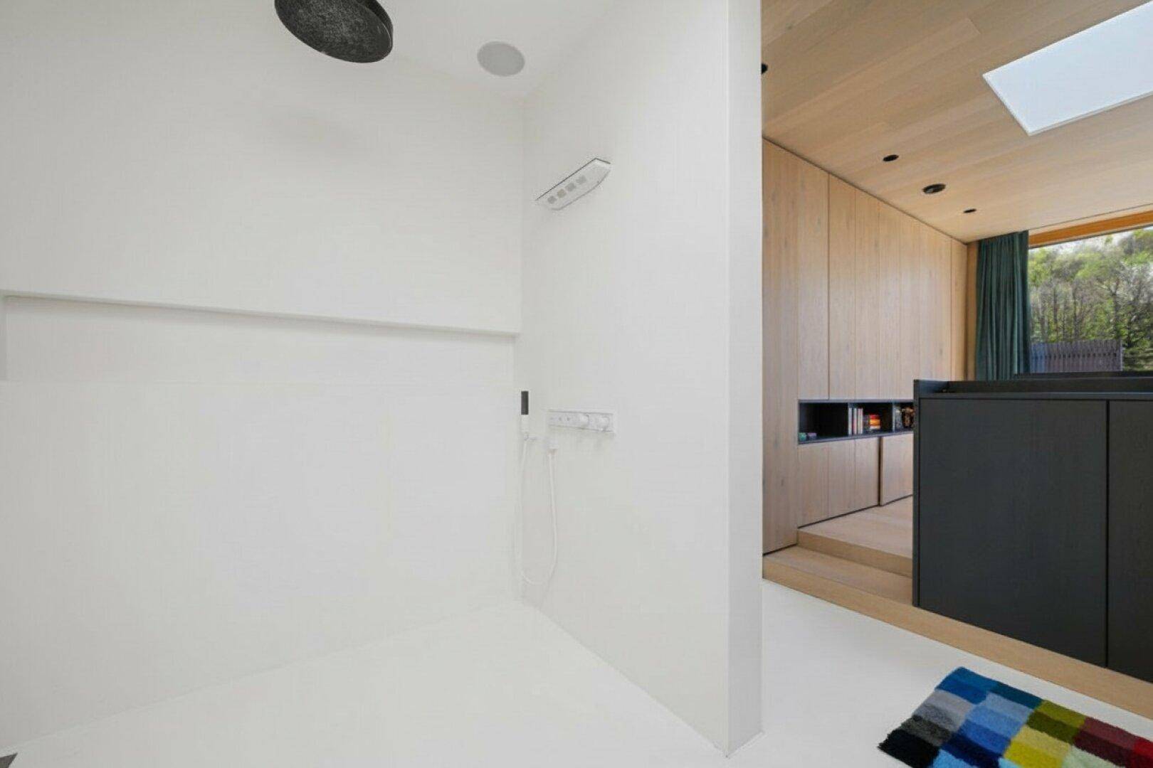 Geräumige, moderne Dusche mit Regenduschkopf und minimalistischem Design.