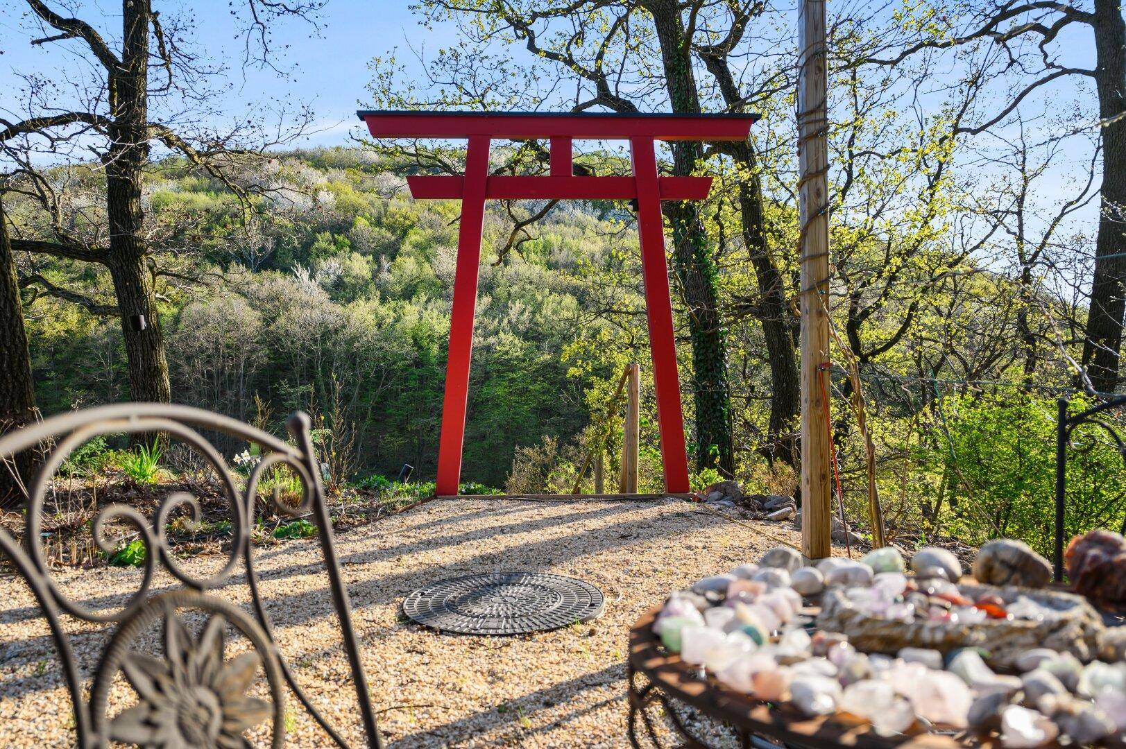 Dekorativer Gartenbereich mit japanischem Tor und Steindekoration.