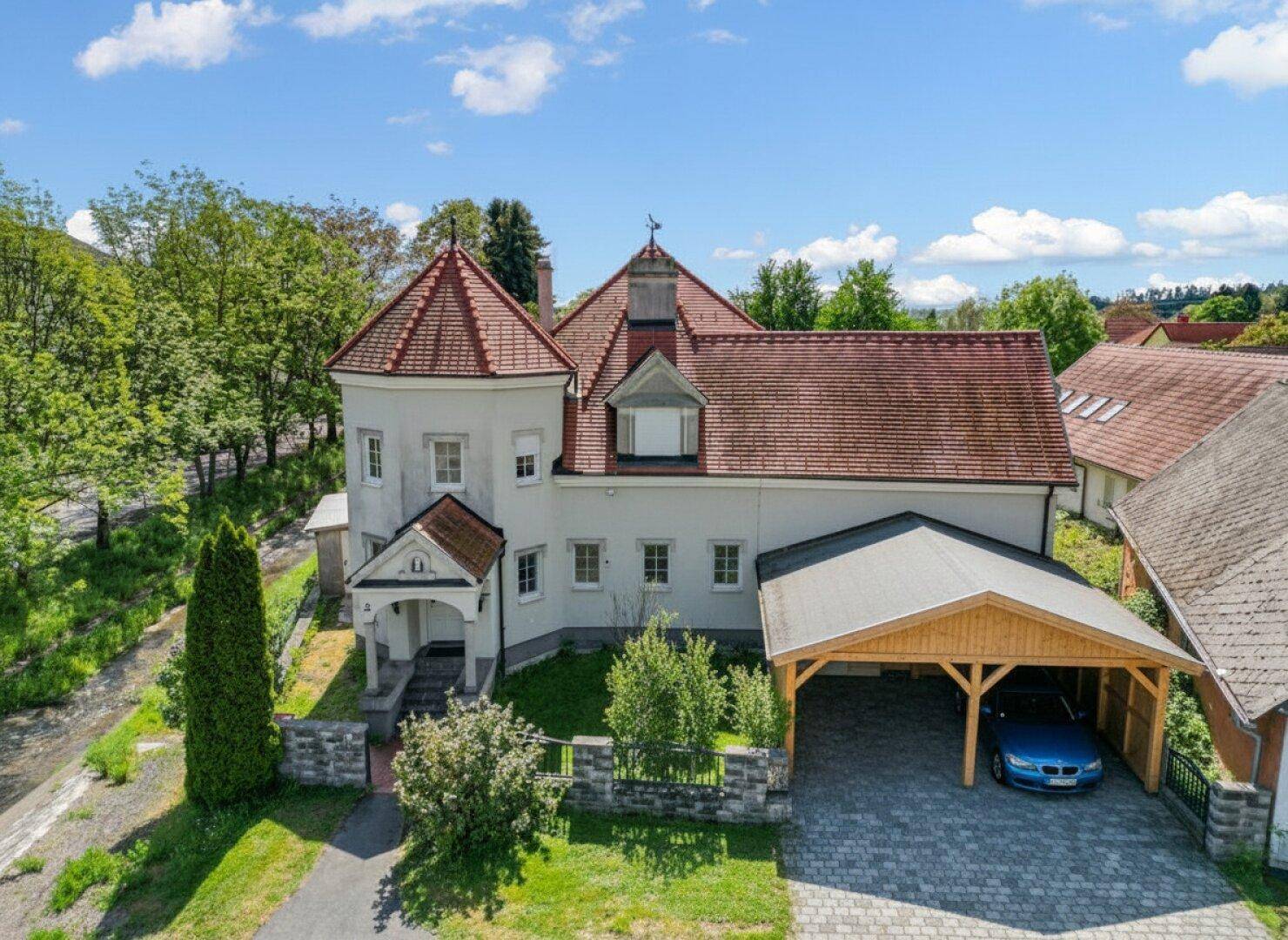Vorderansicht des Hauses mit Carport und gepflegtem Vorgarten.