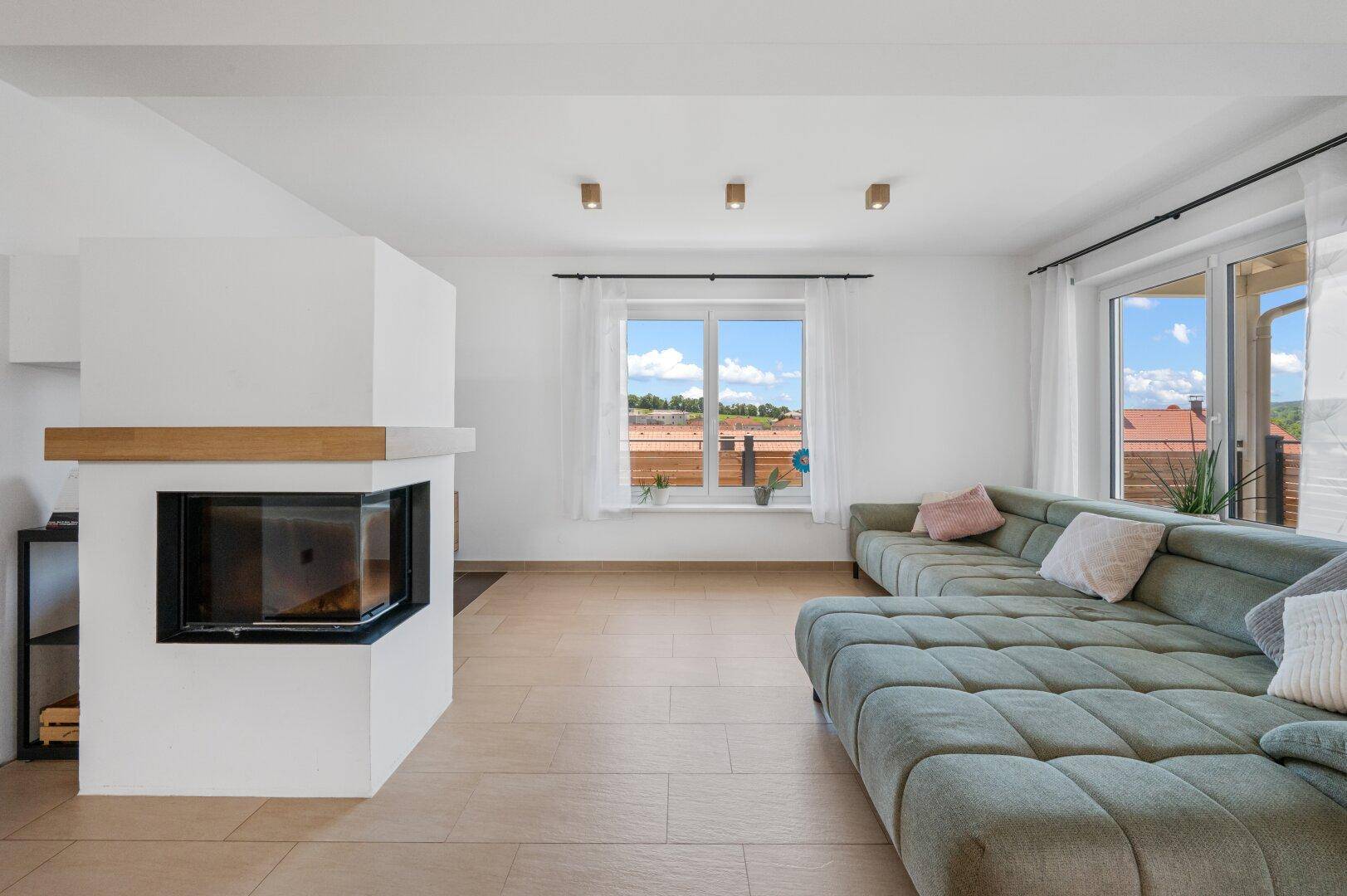 Geräumiges Wohnzimmer mit Kamin und großem Ecksofa, ideal für gesellige Abende.