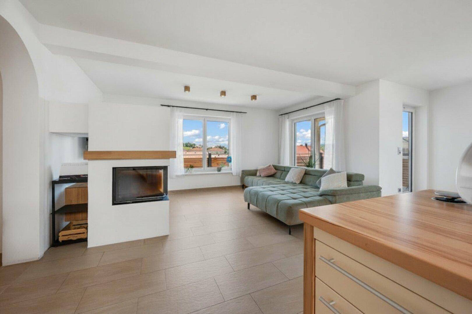 Offener Wohnbereich mit Kamin und Blick auf die Küche, ideal für modernes Wohnen.