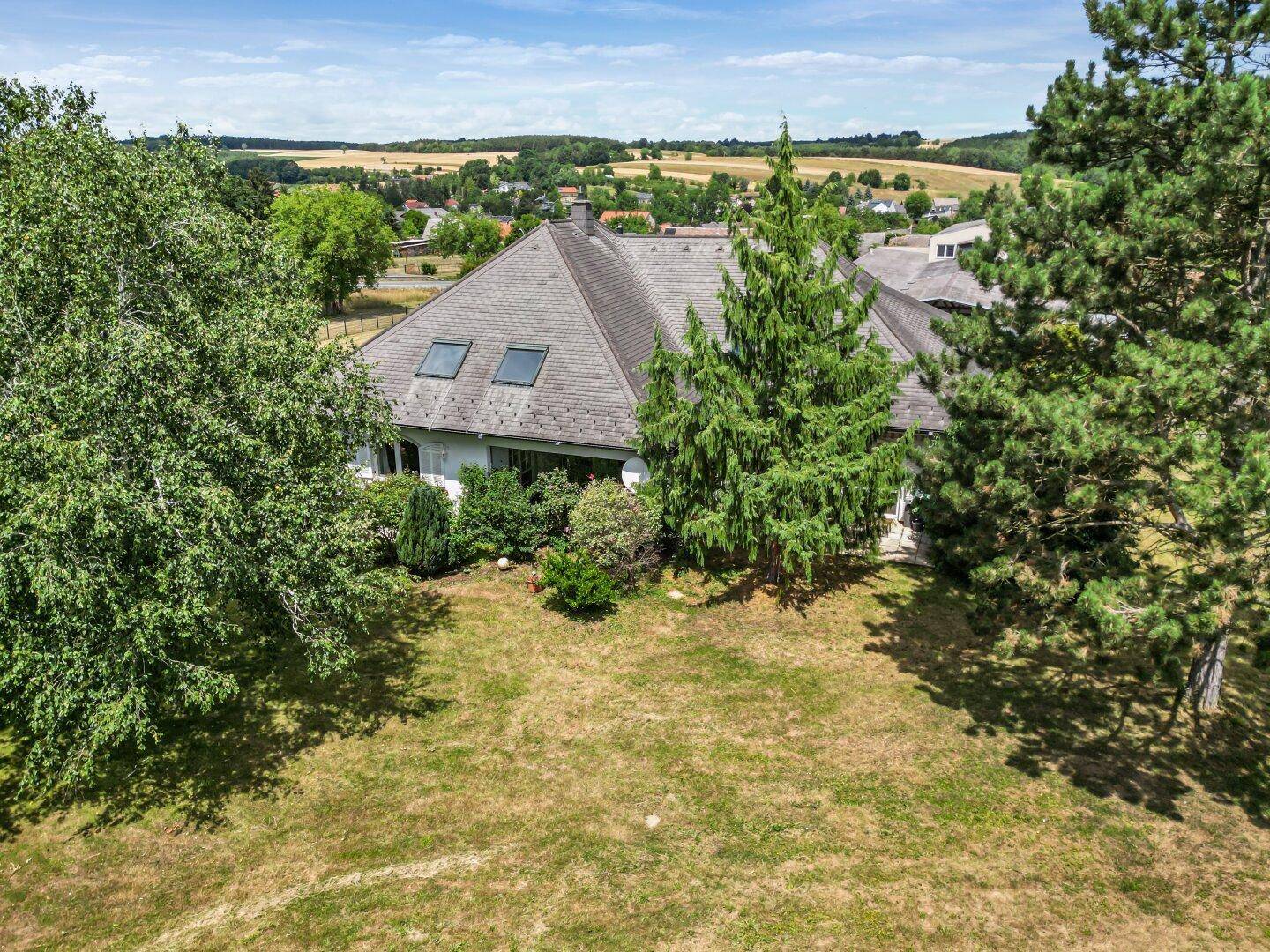 Rückansicht des Hauses mit Dachfenstern und weitem Blick über die ländliche Umgebung.