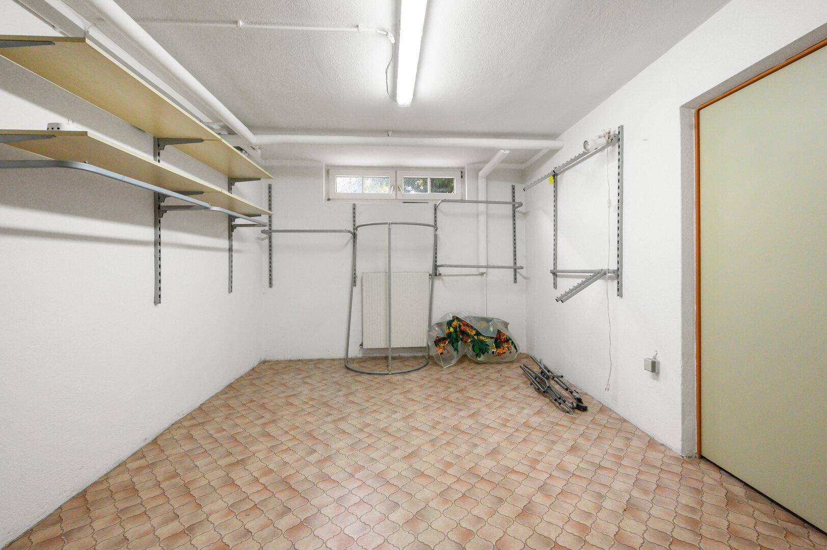 Funktionaler Kellerraum mit Regalsystemen und Fliesenboden, ideal als Abstellfläche.