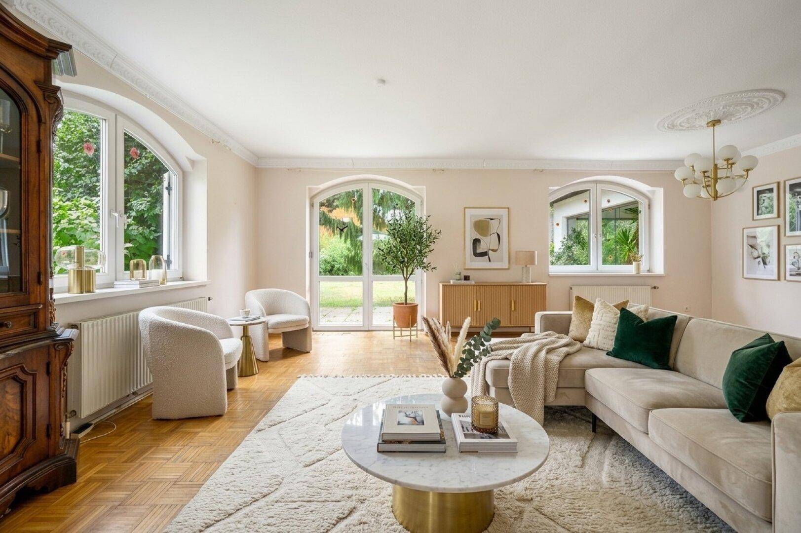Helles Wohnzimmer mit Parkettboden, Stuckdecke und Zugang zum Garten, modern eingerichtet.
