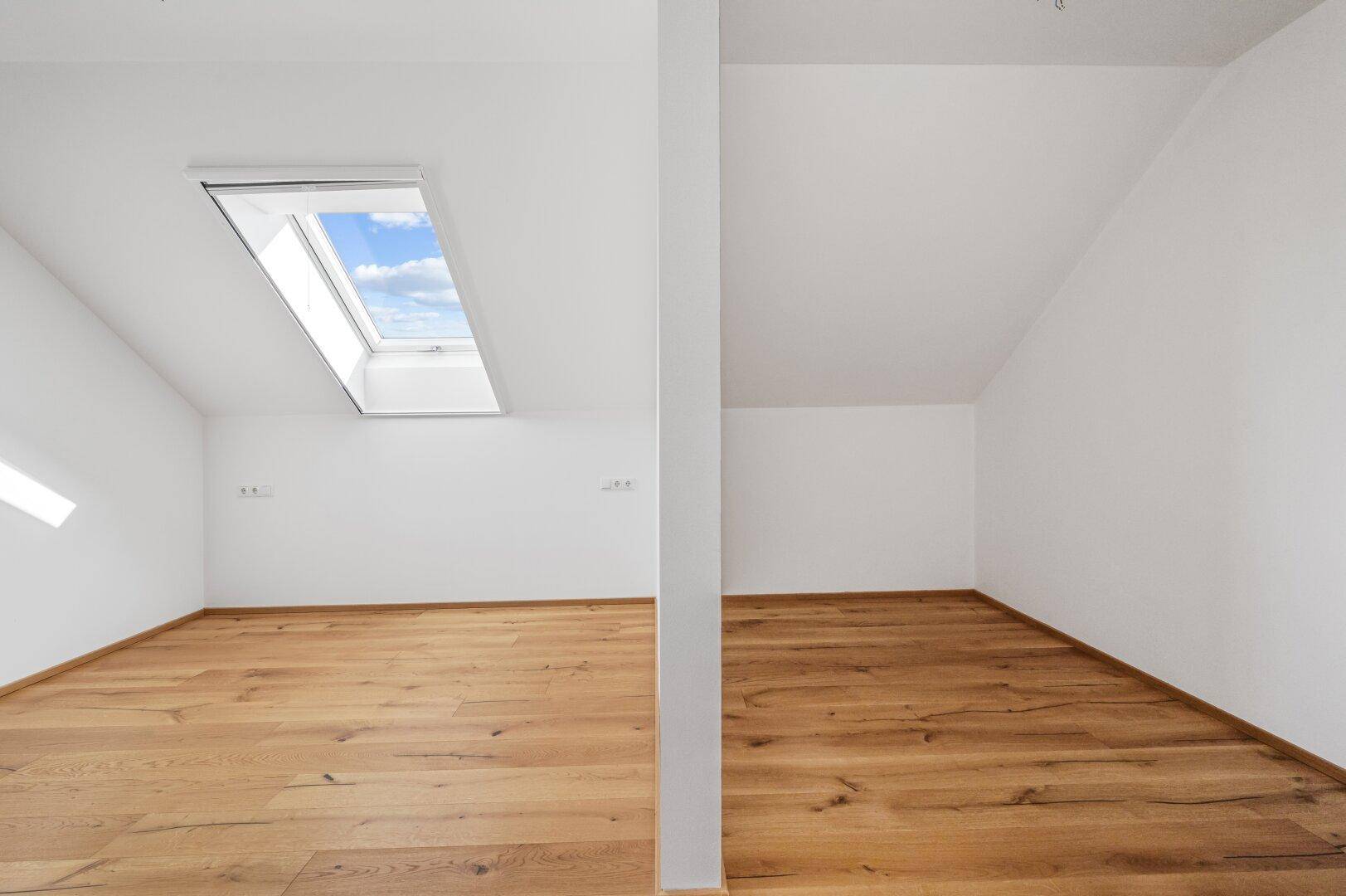 Helles, leeres Zimmer mit Eichenparkett und Dachfenster, ideal als Schlaf- oder Arbeitszimmer.