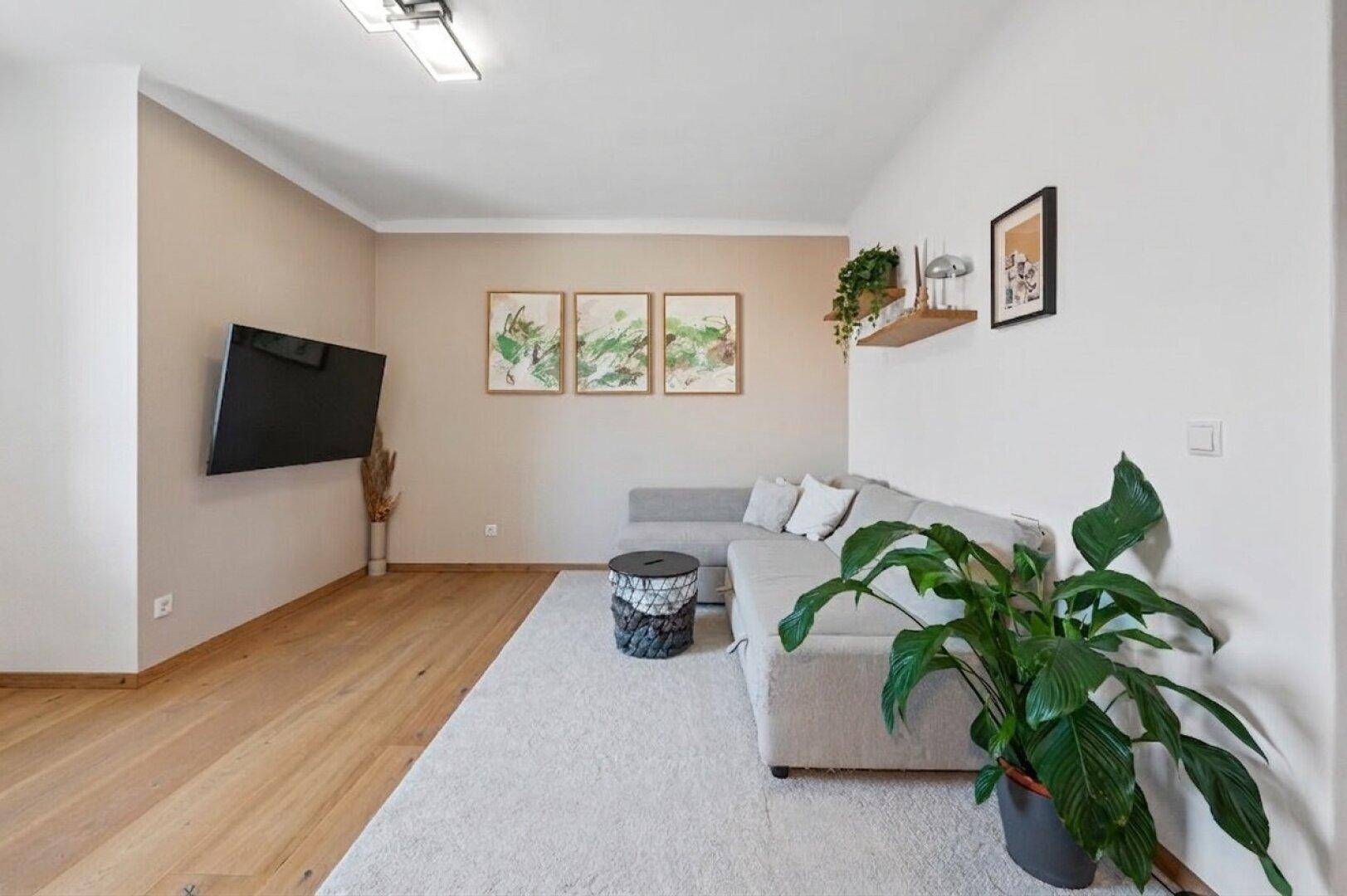 Gemütliches Wohnzimmer mit Ecksofa, Teppich und Wanddekoration, ideal zum Entspannen.