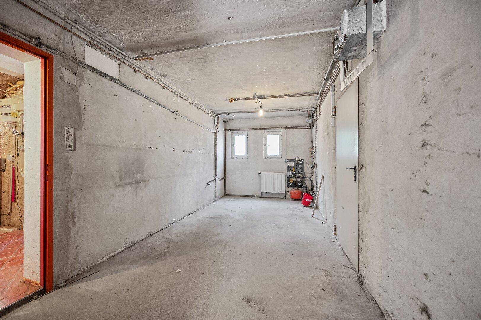 Leerer Kellerraum mit Betonwänden und -boden, bereit für Ausbau oder Nutzung als Lager.