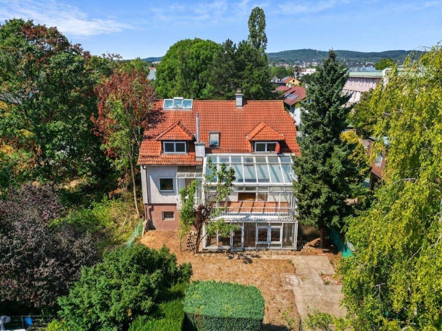 Luftaufnahme des Hauses mit großem Garten und verglastem Anbau vor der Renovierung.