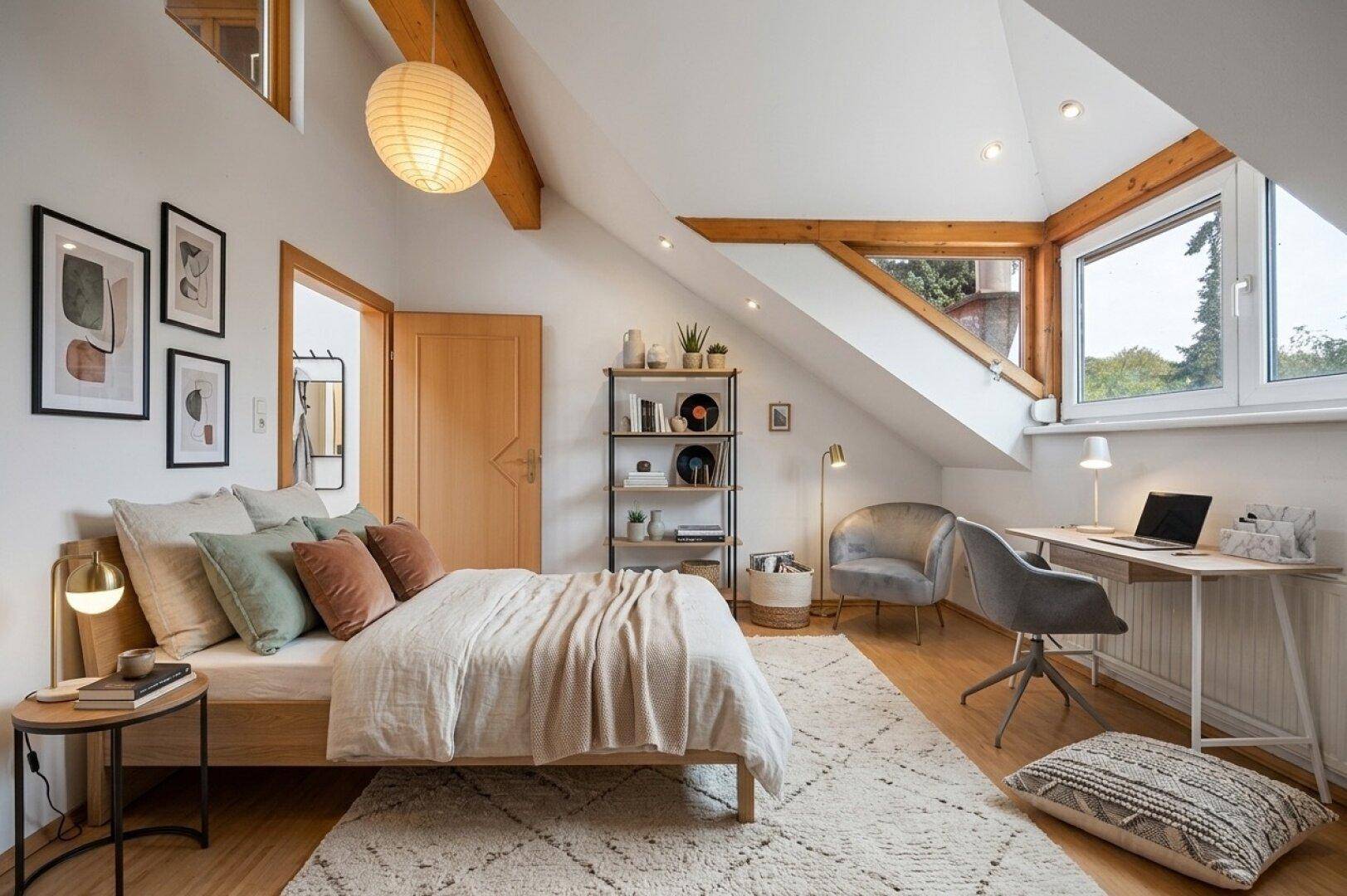 Helles Schlafzimmer mit Dachschräge, Holzbalken, großem Fenster und modernem Arbeitsbereich.