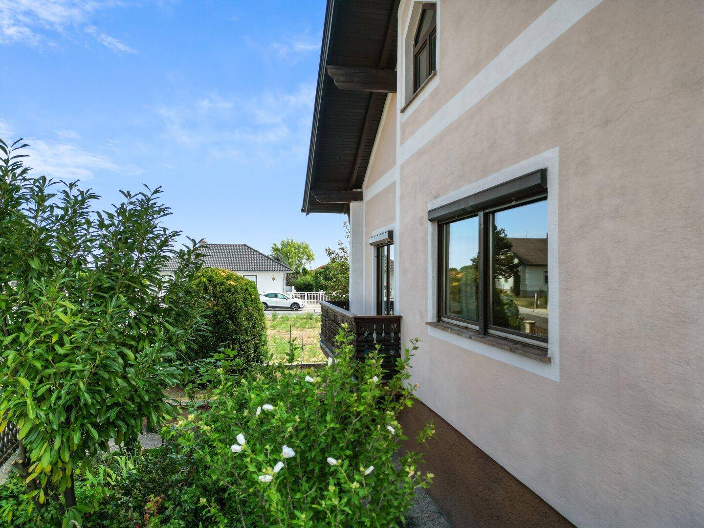 Kleiner Balkon mit Holzgeländer und Blick ins Grüne, ideal für entspannte Stunden.
