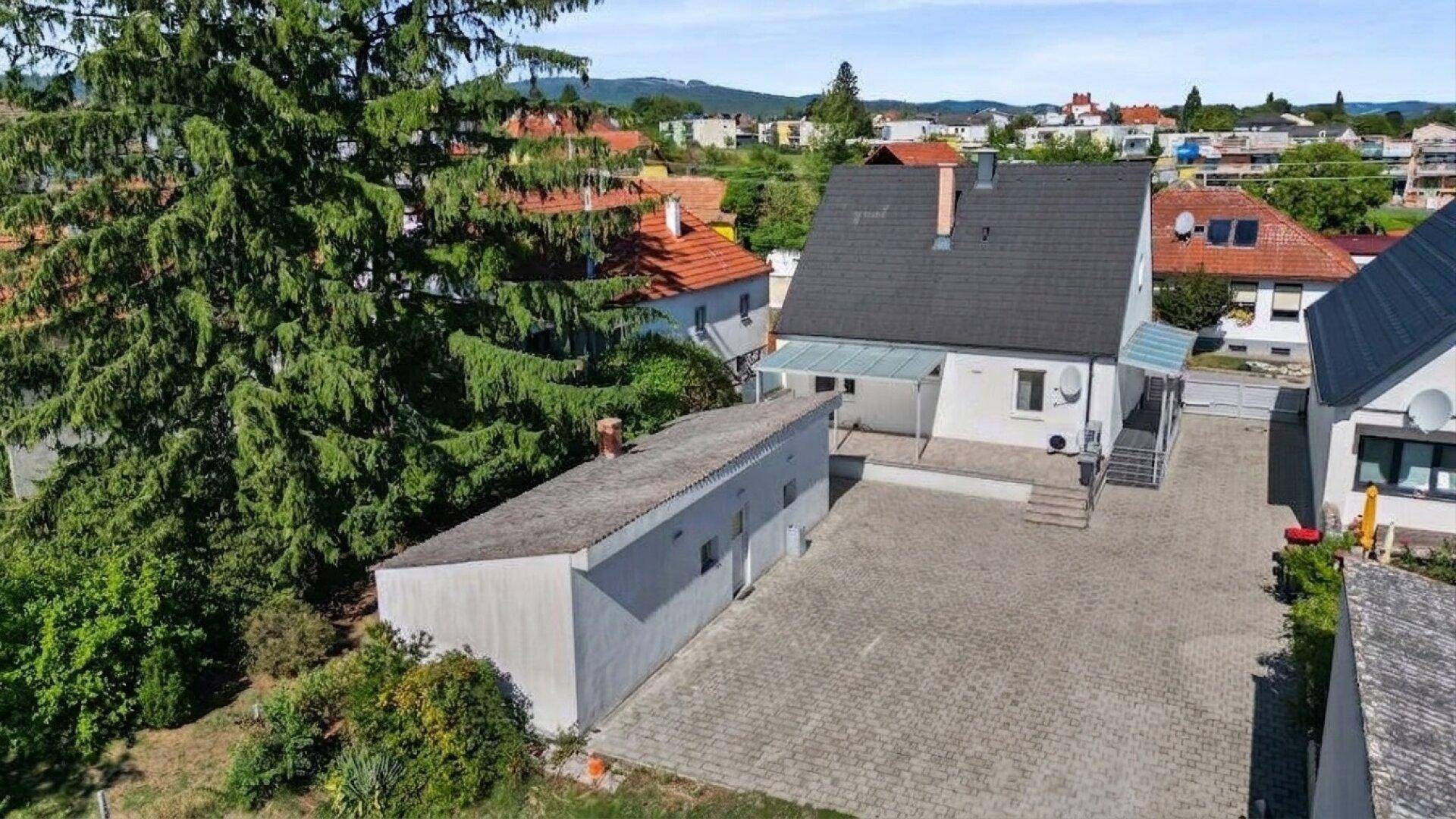 Gesamtansicht des Anwesens von oben mit Haupthaus, Garage und großzügiger Zufahrt.