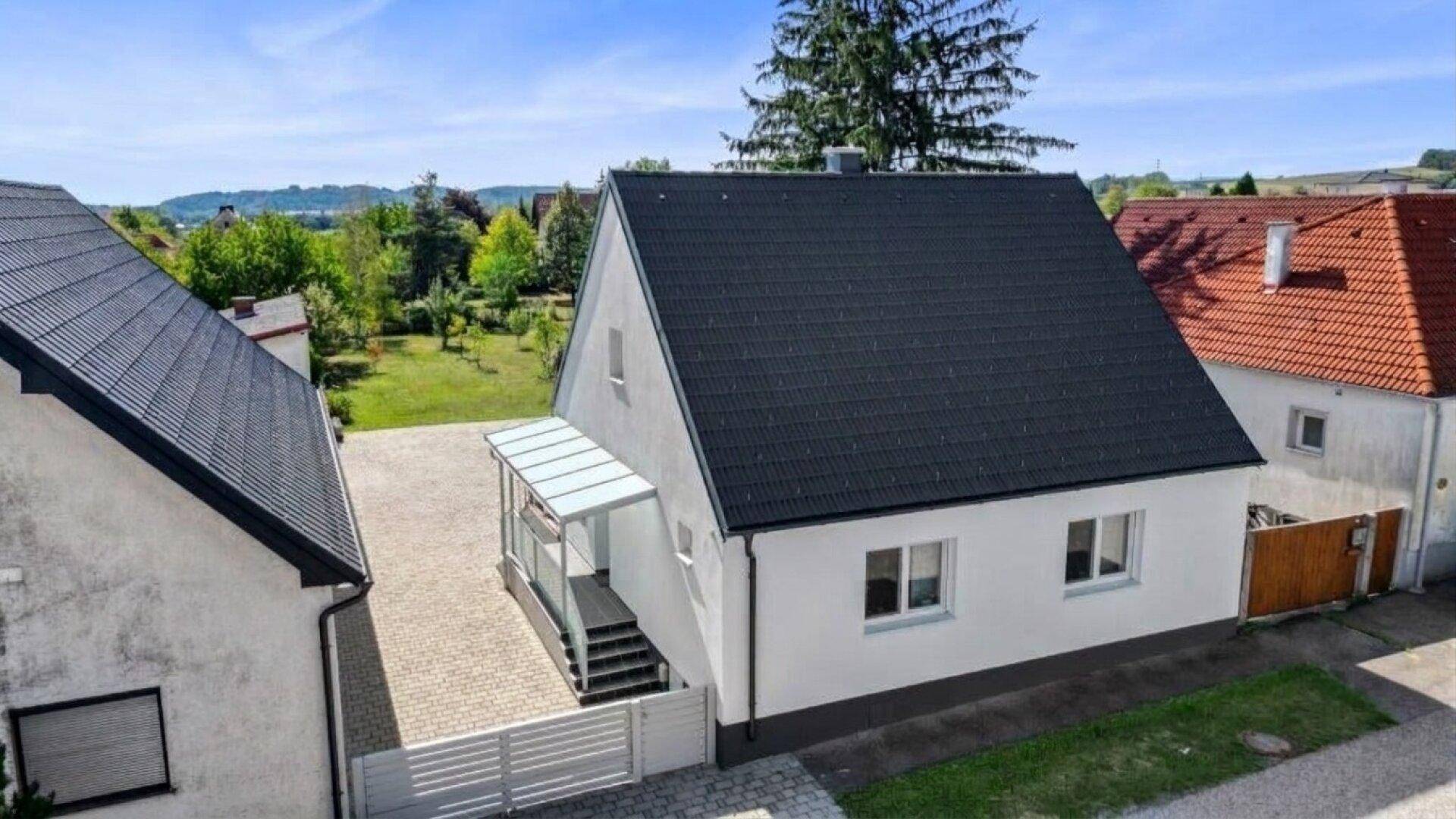 Vogelperspektive des Einfamilienhauses mit Satteldach und gepflegtem Vorgartenbereich.
