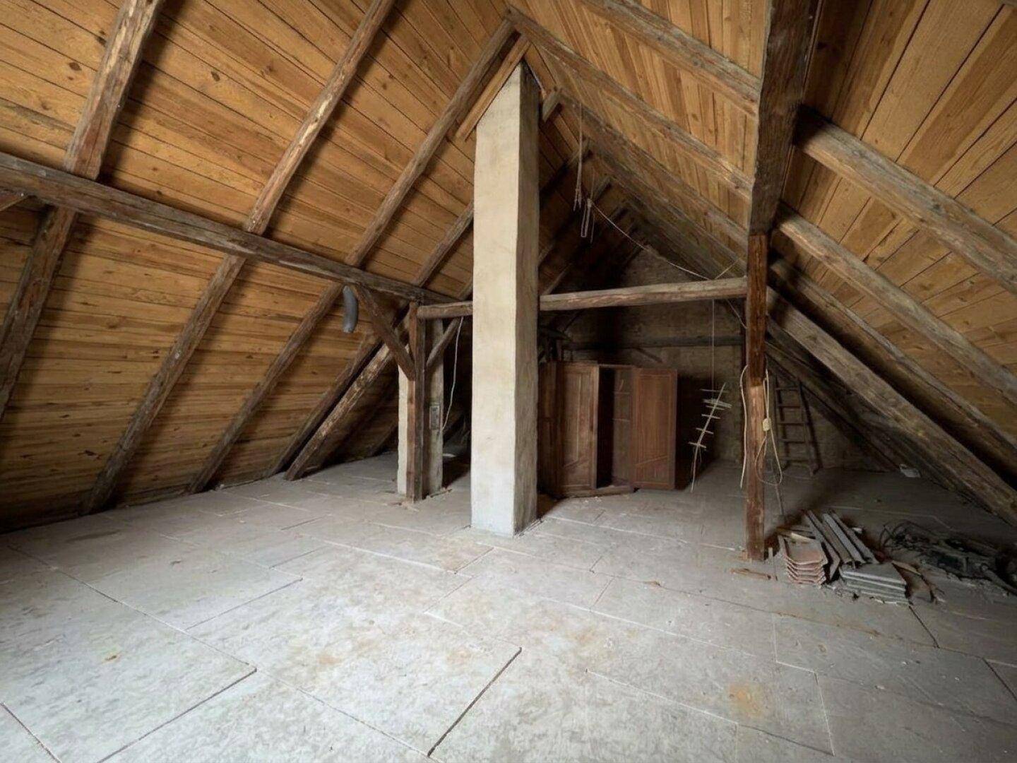 Geräumiger Dachboden mit sichtbaren Holzbalken und viel Potenzial für Ausbau oder Lagerung.