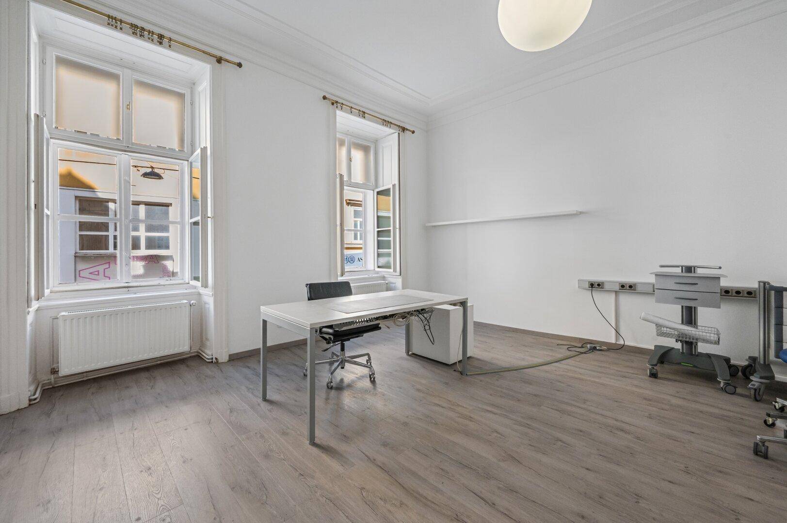 Heller Arbeitsbereich im Ordinationsraum mit großzügigen Fenstern und modernem Schreibtisch, ideal für konzentriertes Arbeiten.