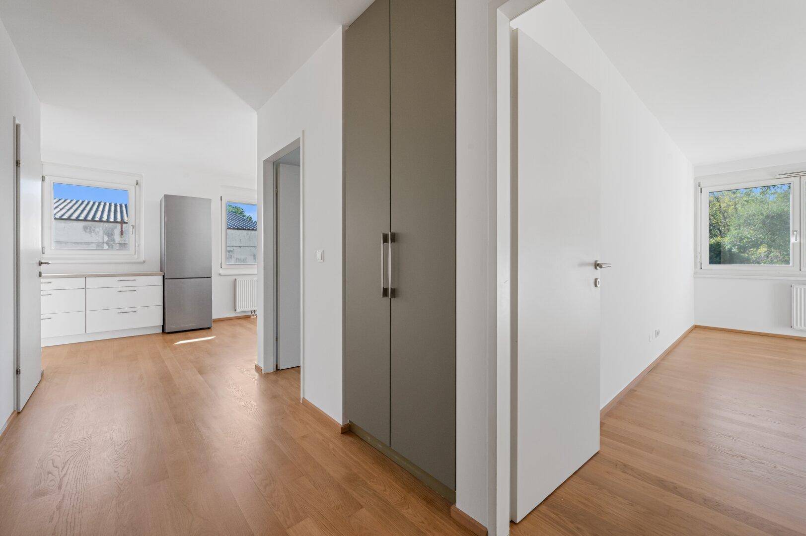 Heller Flur mit Einbauschrank und Zugang zu verschiedenen Räumen.
