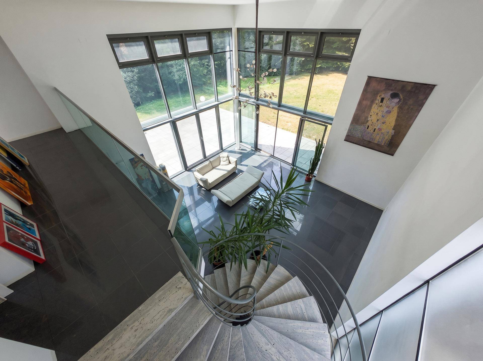 Offener Wohnbereich von oben gesehen mit eleganter Wendeltreppe und viel Tageslicht.