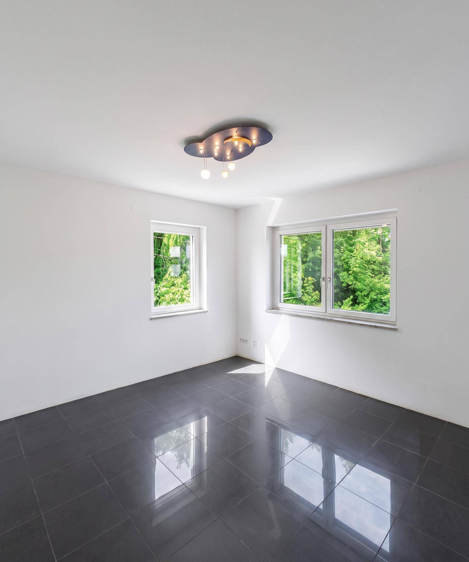 Helles Zimmer mit zwei Fenstern und Blick ins Grüne, ideal als Schlaf- oder Arbeitszimmer.