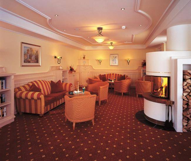 Gemütlicher Loungebereich mit traditionellem Kamin, bequemen Sofas und warmem Licht.