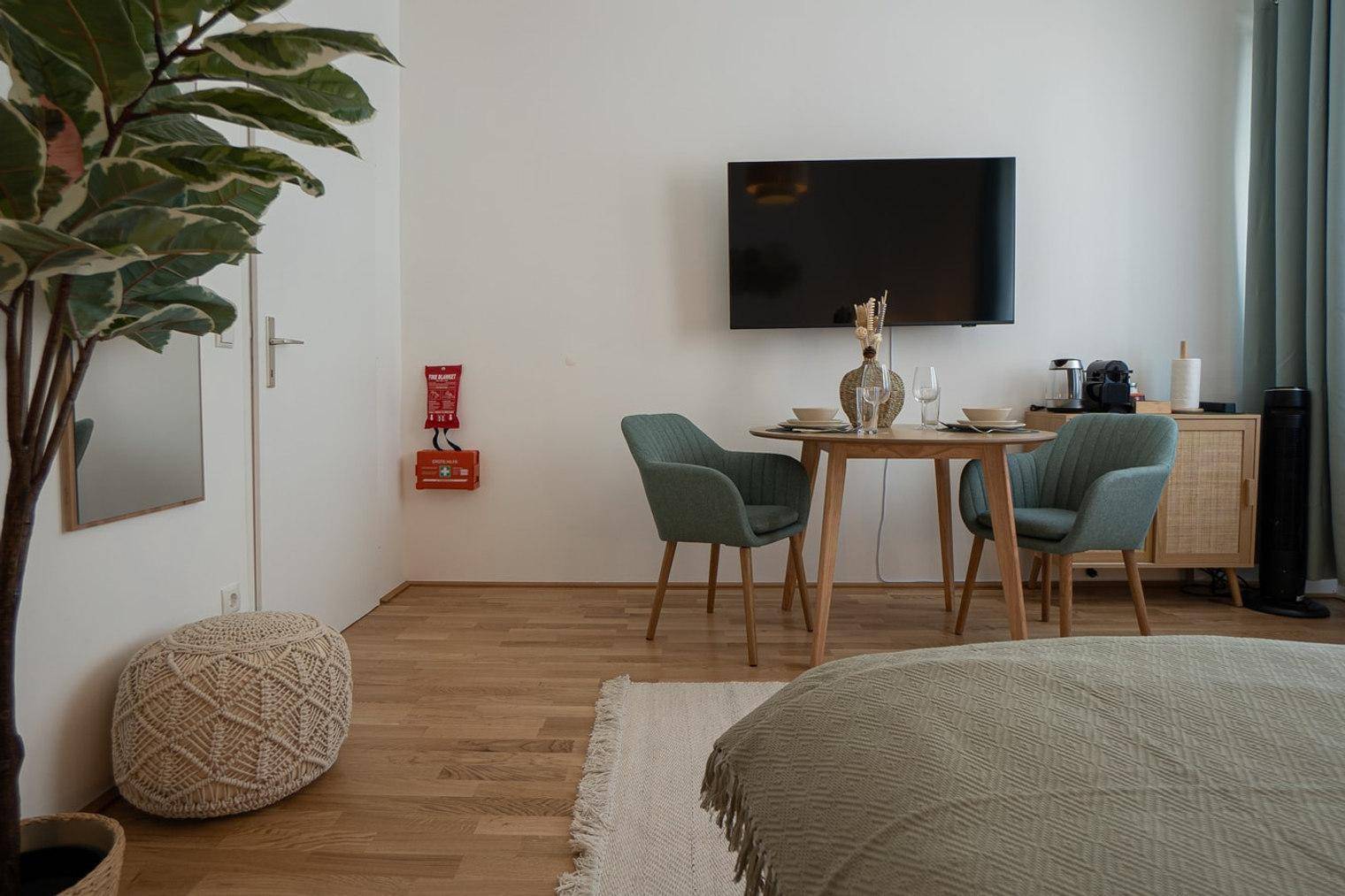 Detailansicht des Esstisches im Schlafzimmer mit Blick auf den Fernseher und moderne Einrichtung.
