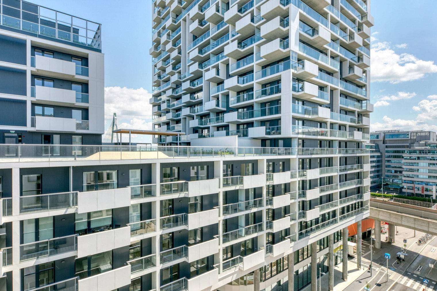 Beeindruckendes modernes Hochhaus mit vielen Balkonen und Glasfassaden.