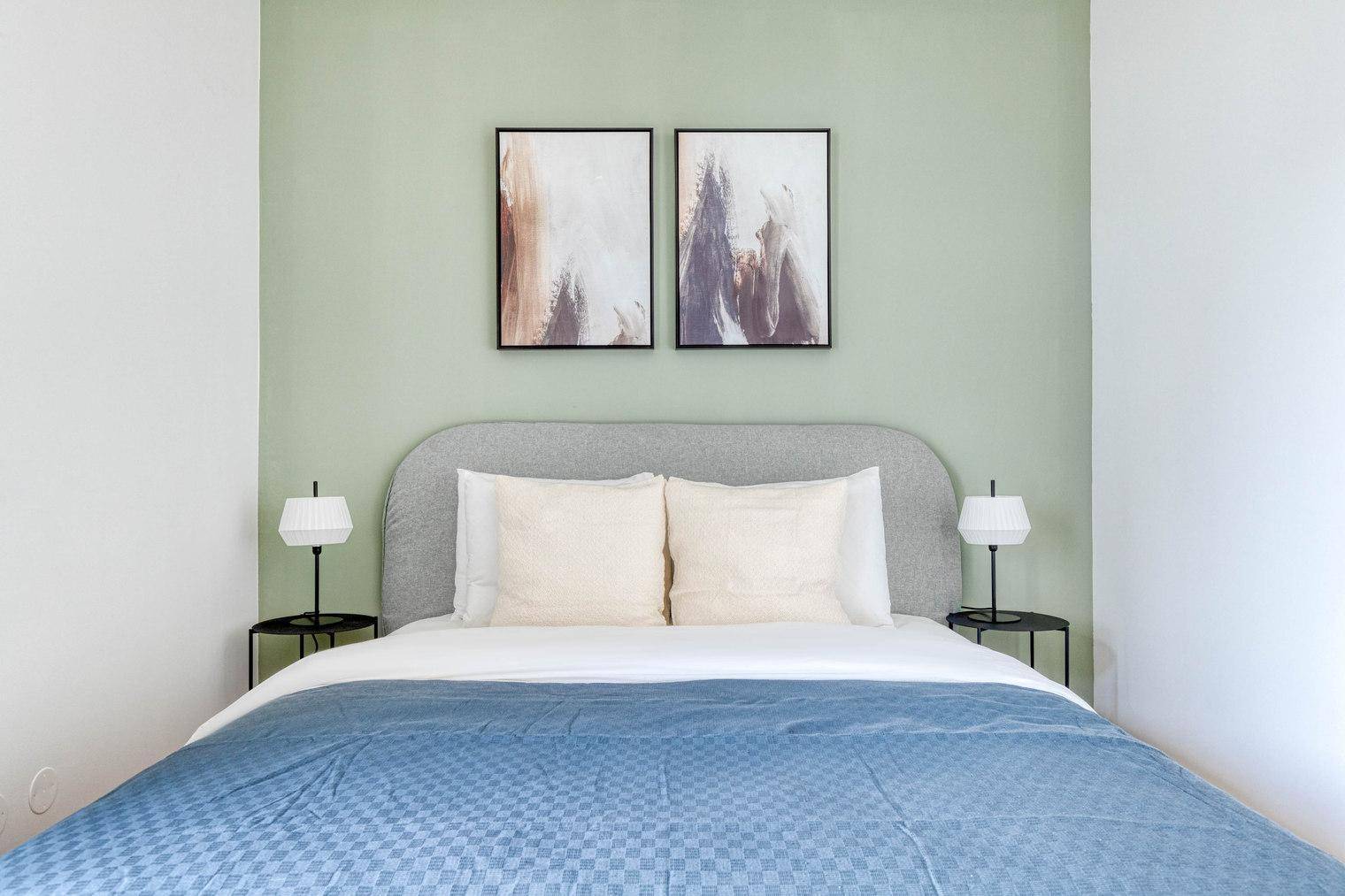 Gemütliches Schlafzimmer mit Doppelbett, Nachttischen und Kunst an der Wand.