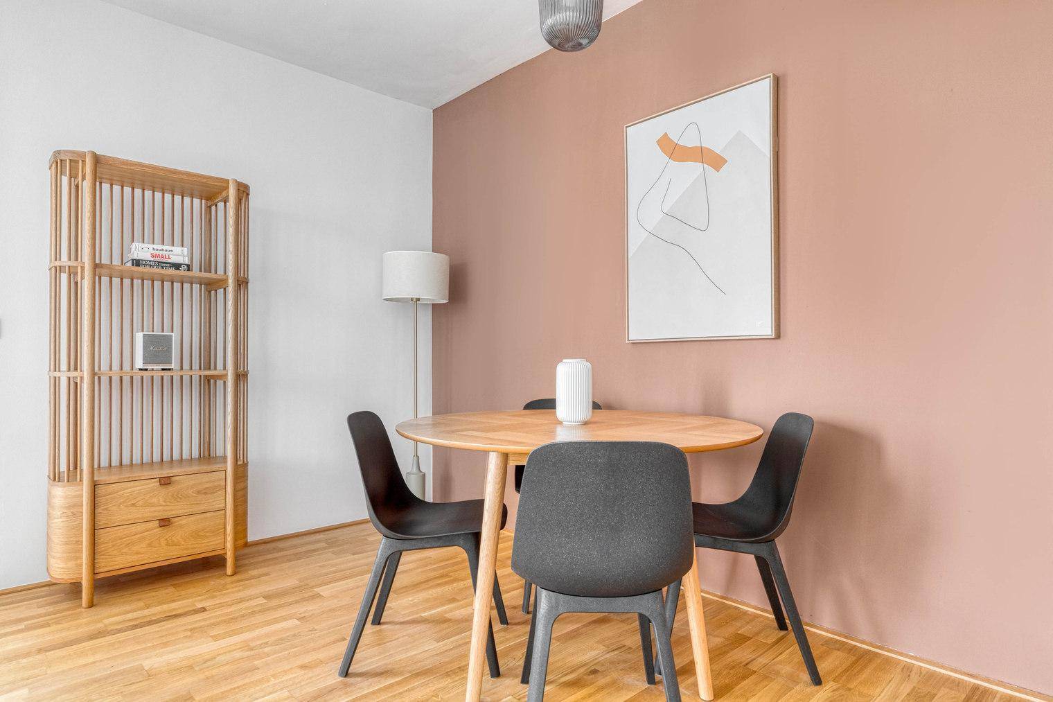 Heller Essbereich mit Holztisch, modernen Stühlen und Akzentwand.