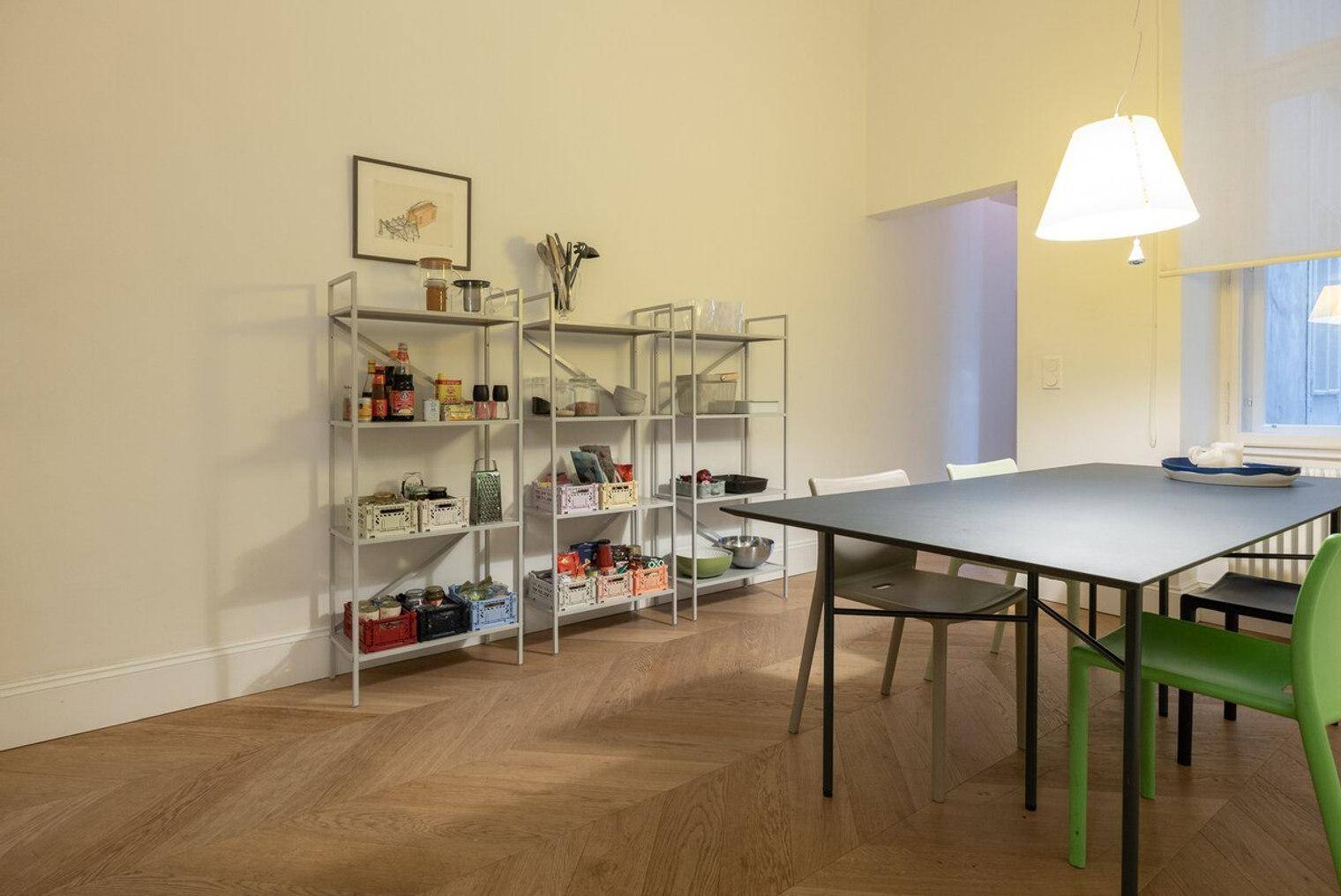 Essbereich mit modernem Tisch und Stühlen, umgeben von praktischen Regalen für zusätzlichen Stauraum.