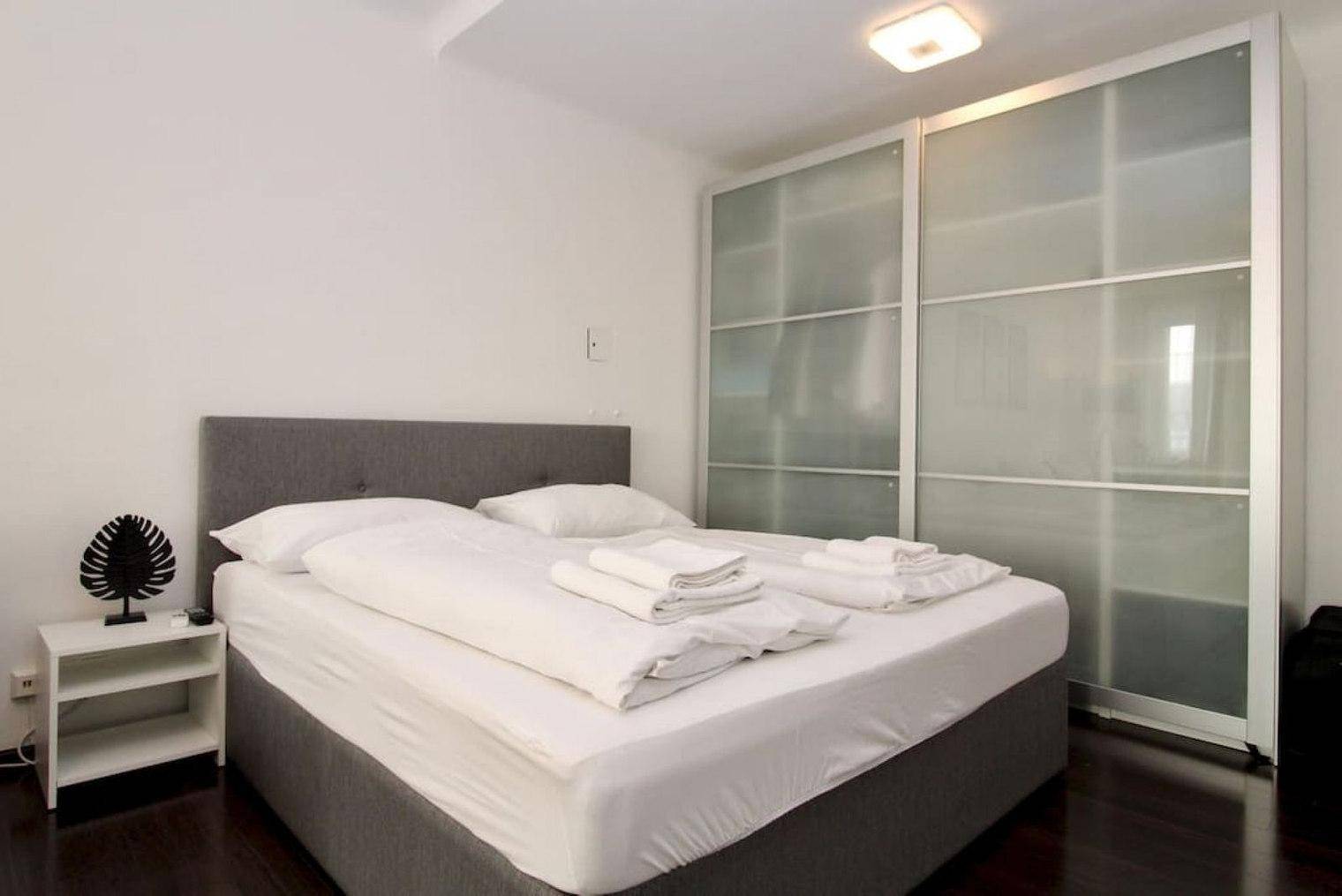 Schlafbereich mit Doppelbett und großem Schiebetürenschrank.