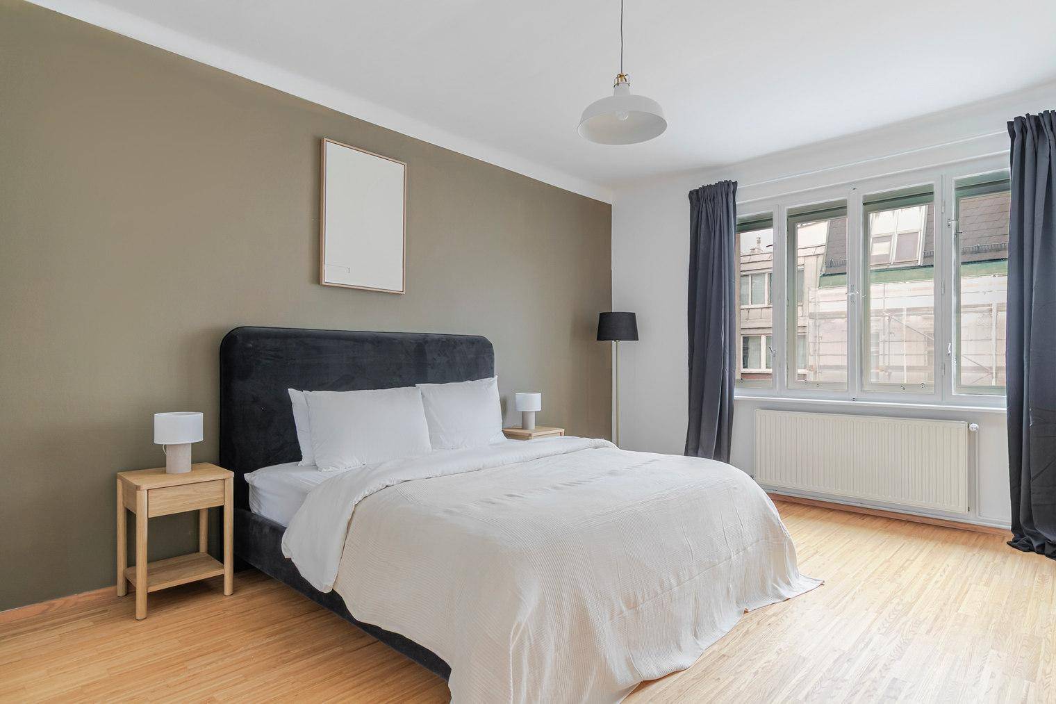 Geräumiges Schlafzimmer mit Doppelbett, Holzboden und brauner Akzentwand.