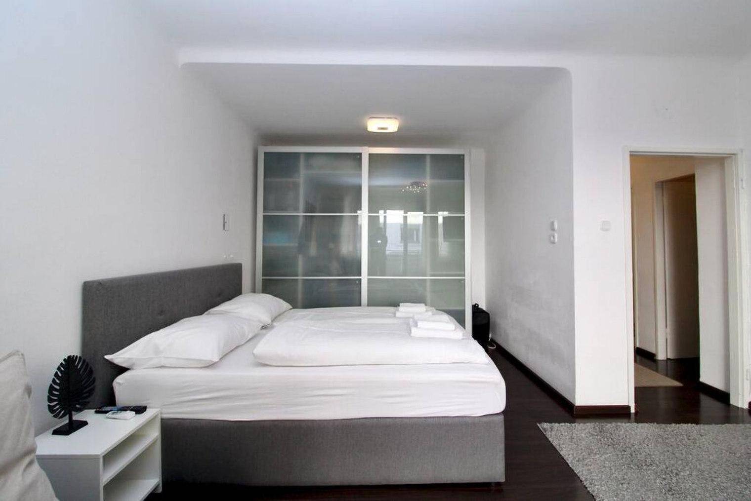 Schlafbereich mit Doppelbett und großem Schiebetürenschrank, angrenzend an den Flur.
