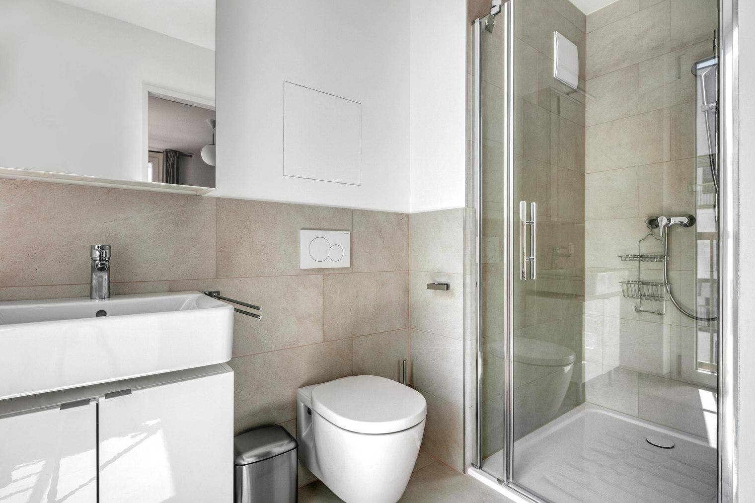 Modernes Badezimmer mit Dusche, wandhängendem WC und Einzelwaschbecken.