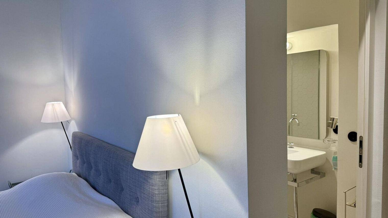 Schlafzimmer mit indirekter Beleuchtung und Blick auf das angrenzende Badezimmer.