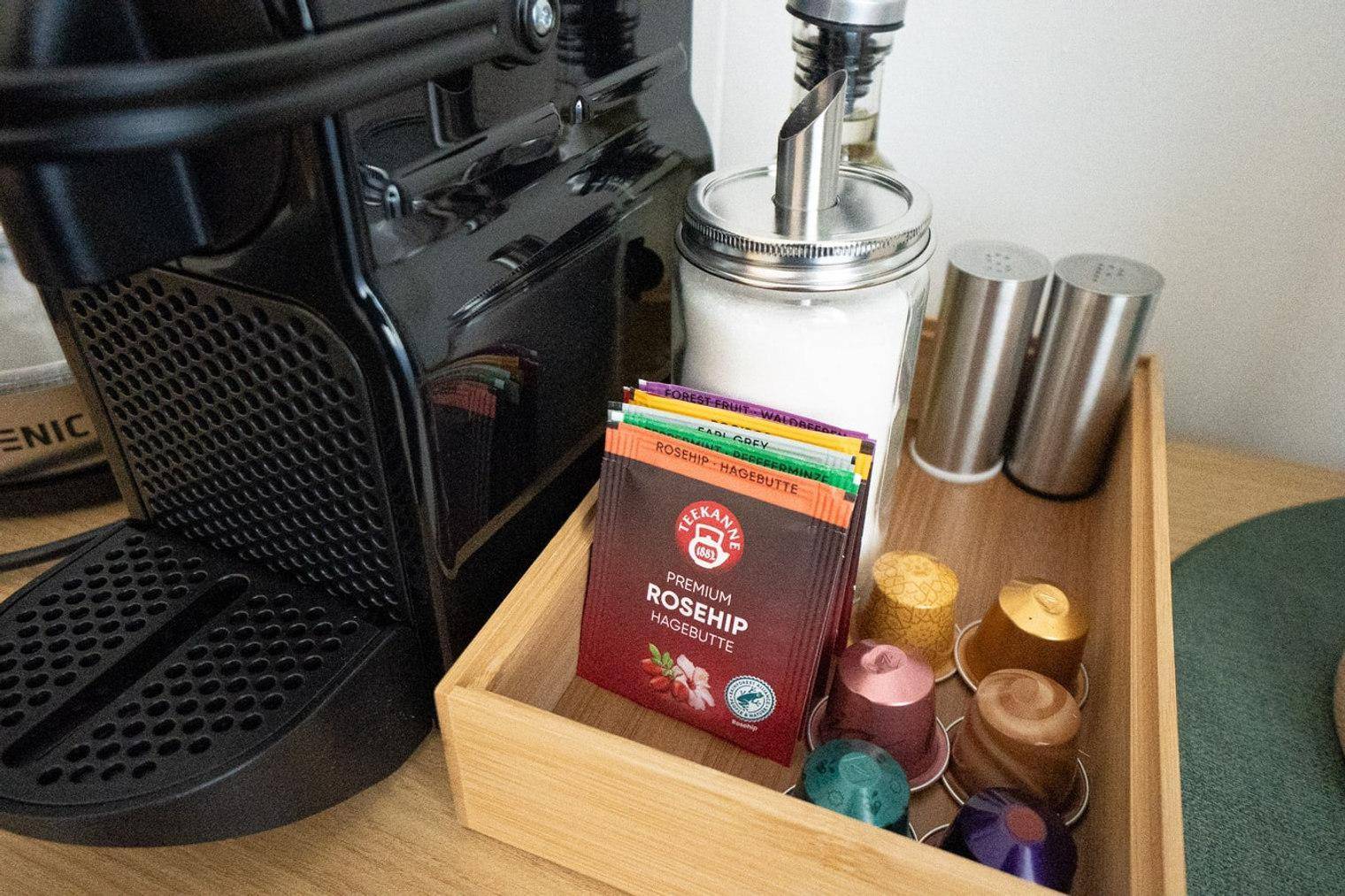 Kaffeemaschine und Teezubehör auf einem Sideboard, bereit für den täglichen Genuss.