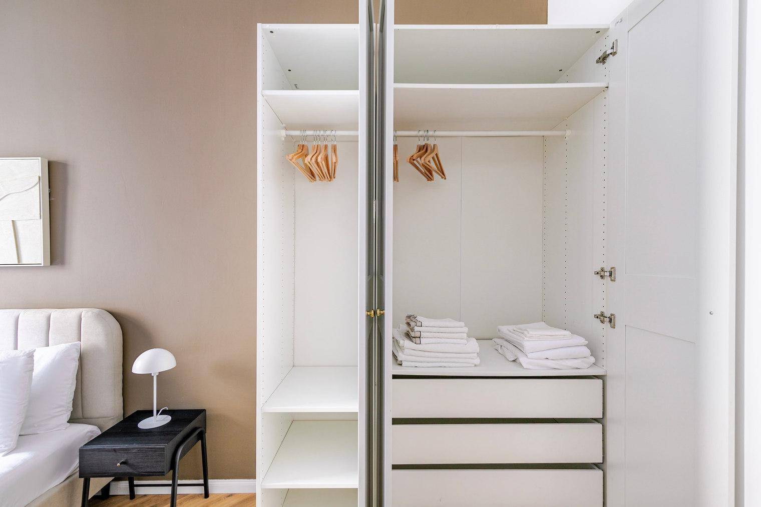 Offener Kleiderschrank im Schlafzimmer mit ausreichend Stauraum und Ablagemöglichkeiten.