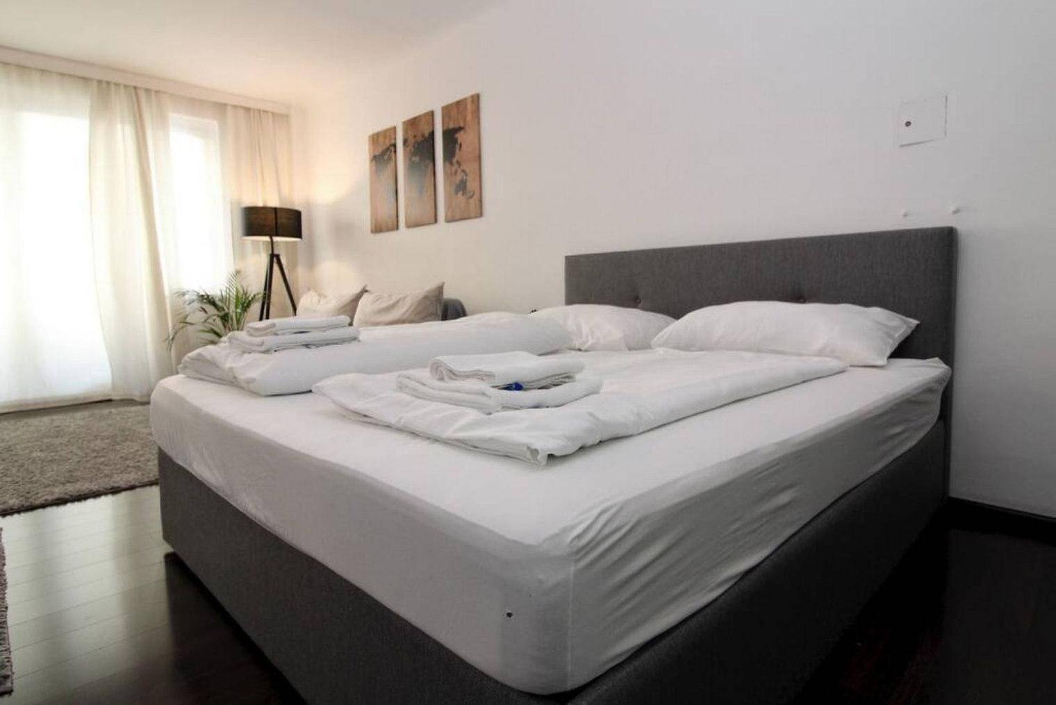 Komfortables Doppelbett im Schlafbereich mit Blick auf den Balkon und hellem Ambiente.