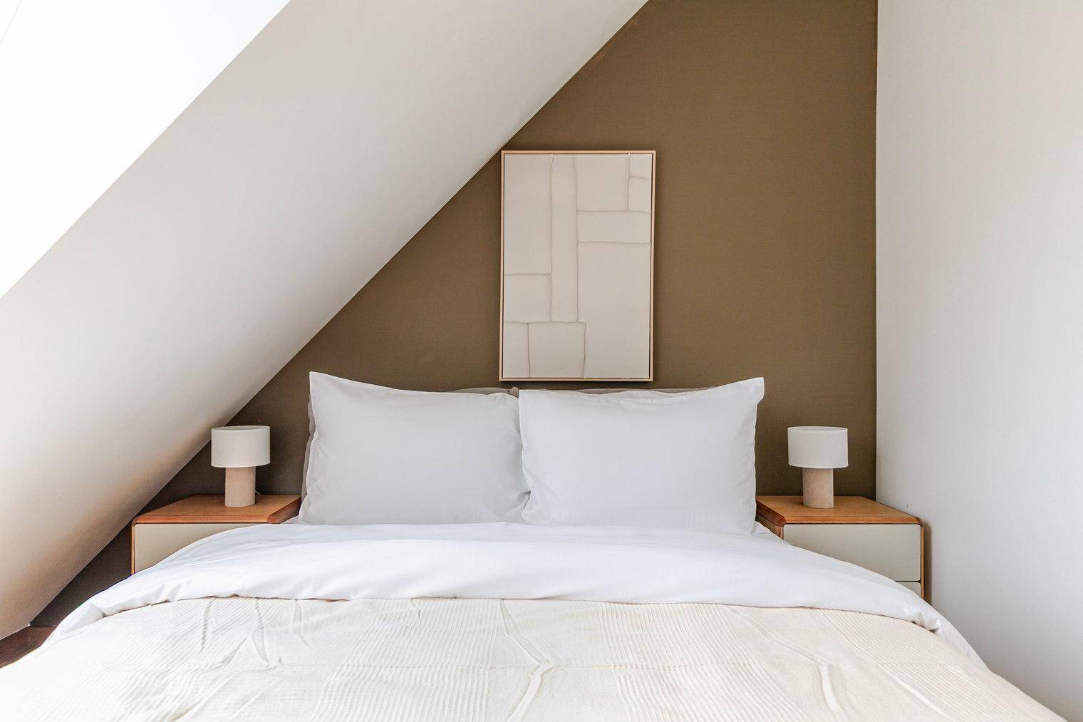 Modern eingerichtetes Schlafzimmer mit bequemen Bett und minimalistischer Dekoration.