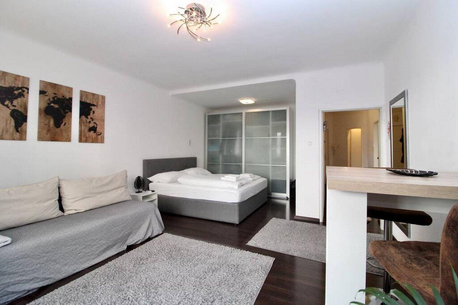 Kombinierter Wohn- und Schlafbereich mit Sofa, Doppelbett und großem Kleiderschrank.