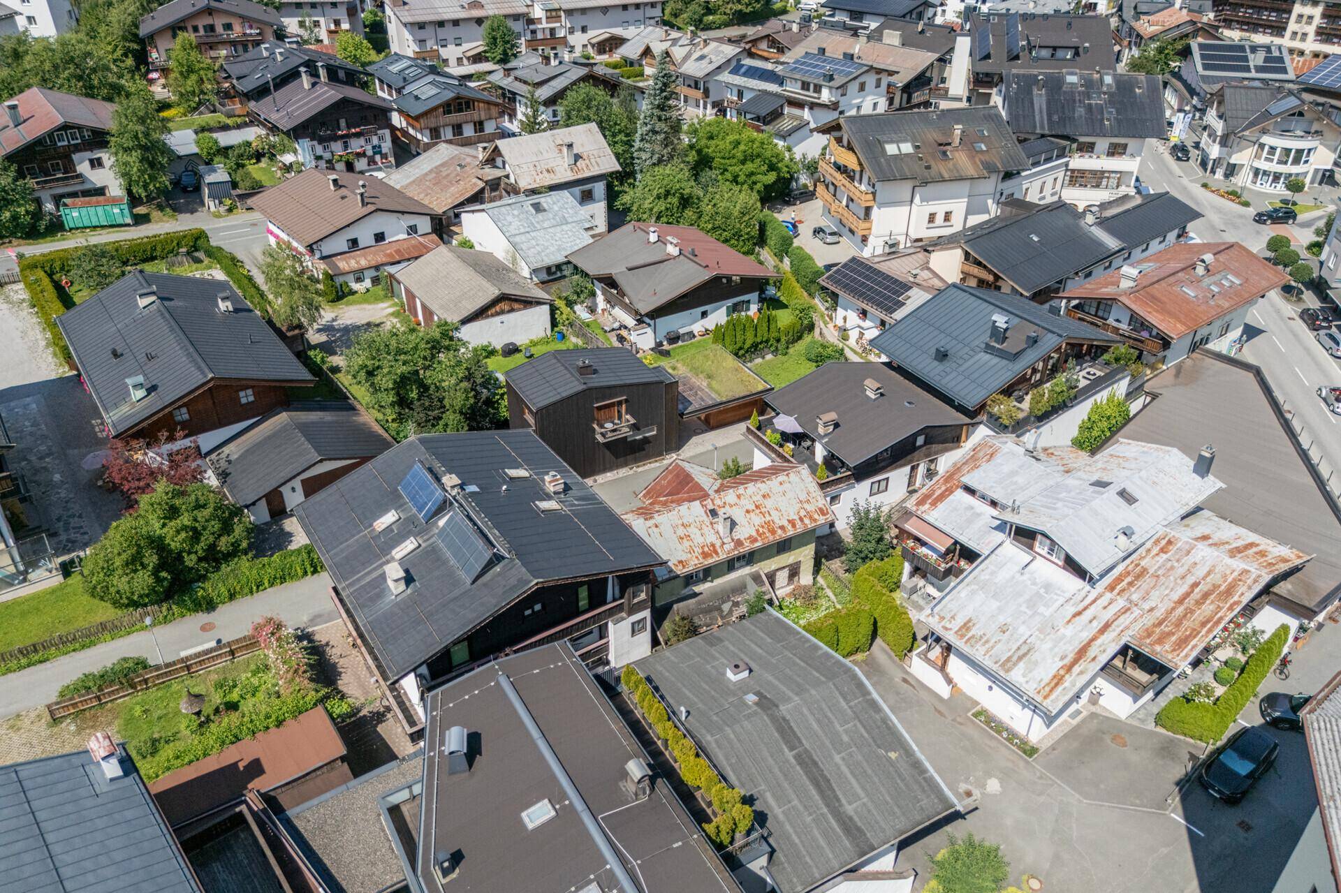 Panoramablick aus der Vogelperspektive auf die Dächer der Häuser in einer grünen Wohngegend mit Bergsicht.