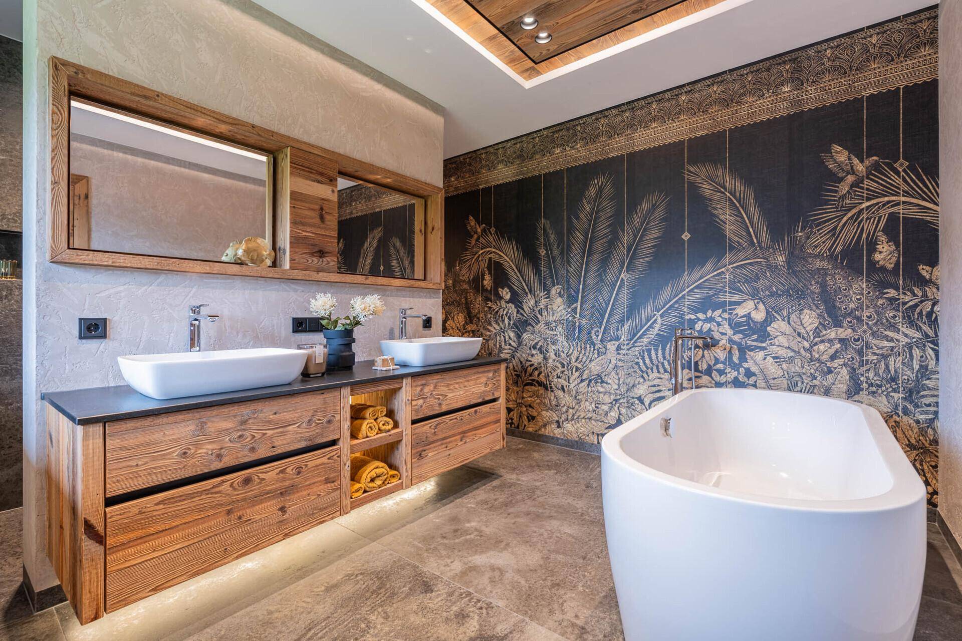 Luxuriöses Badezimmer mit freistehender Badewanne, Doppelwaschbecken und einer auffälligen Wandtapete.