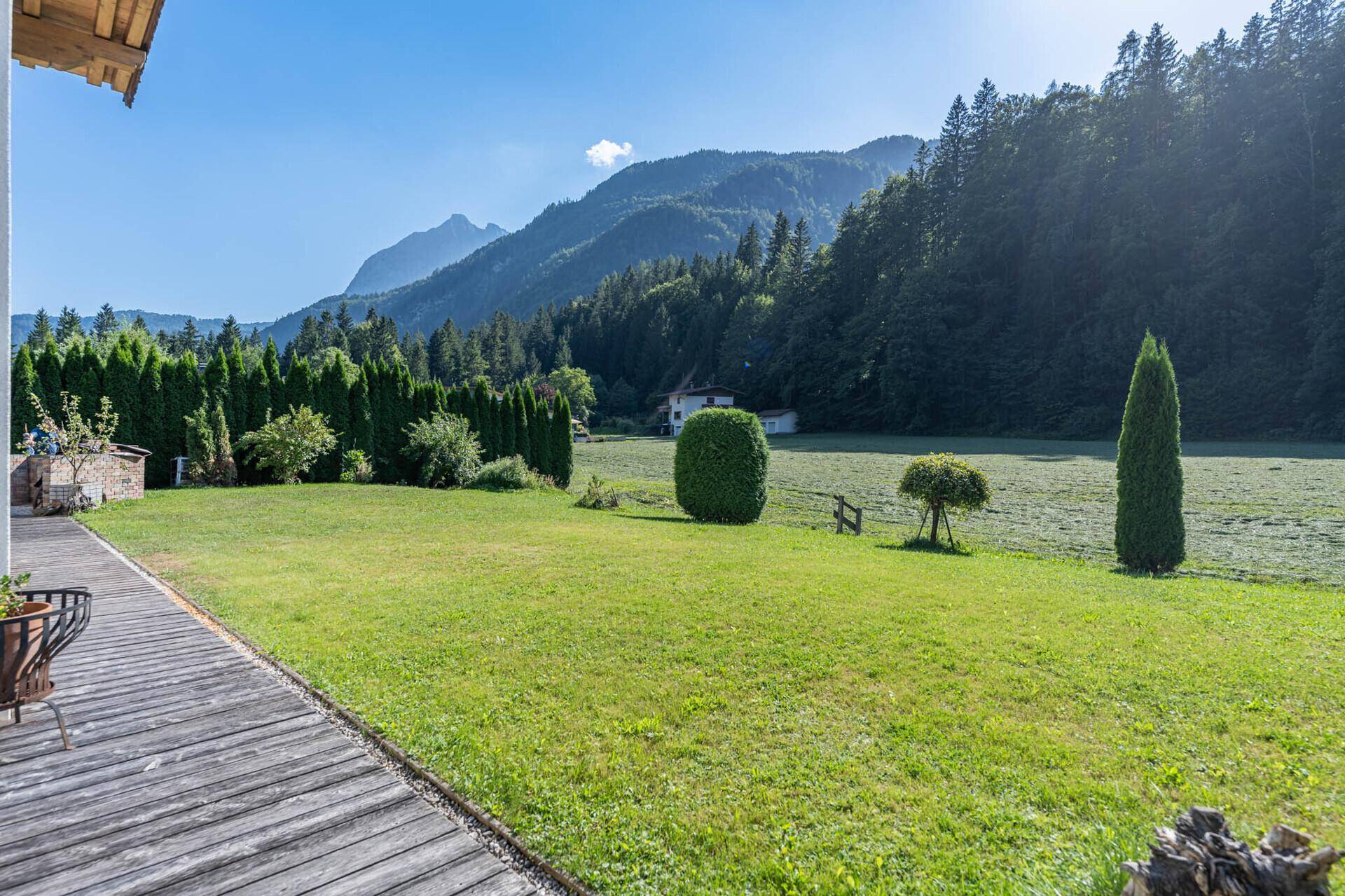 Weitläufiger Garten mit Rasenfläche und beeindruckendem Blick auf die Alpen.