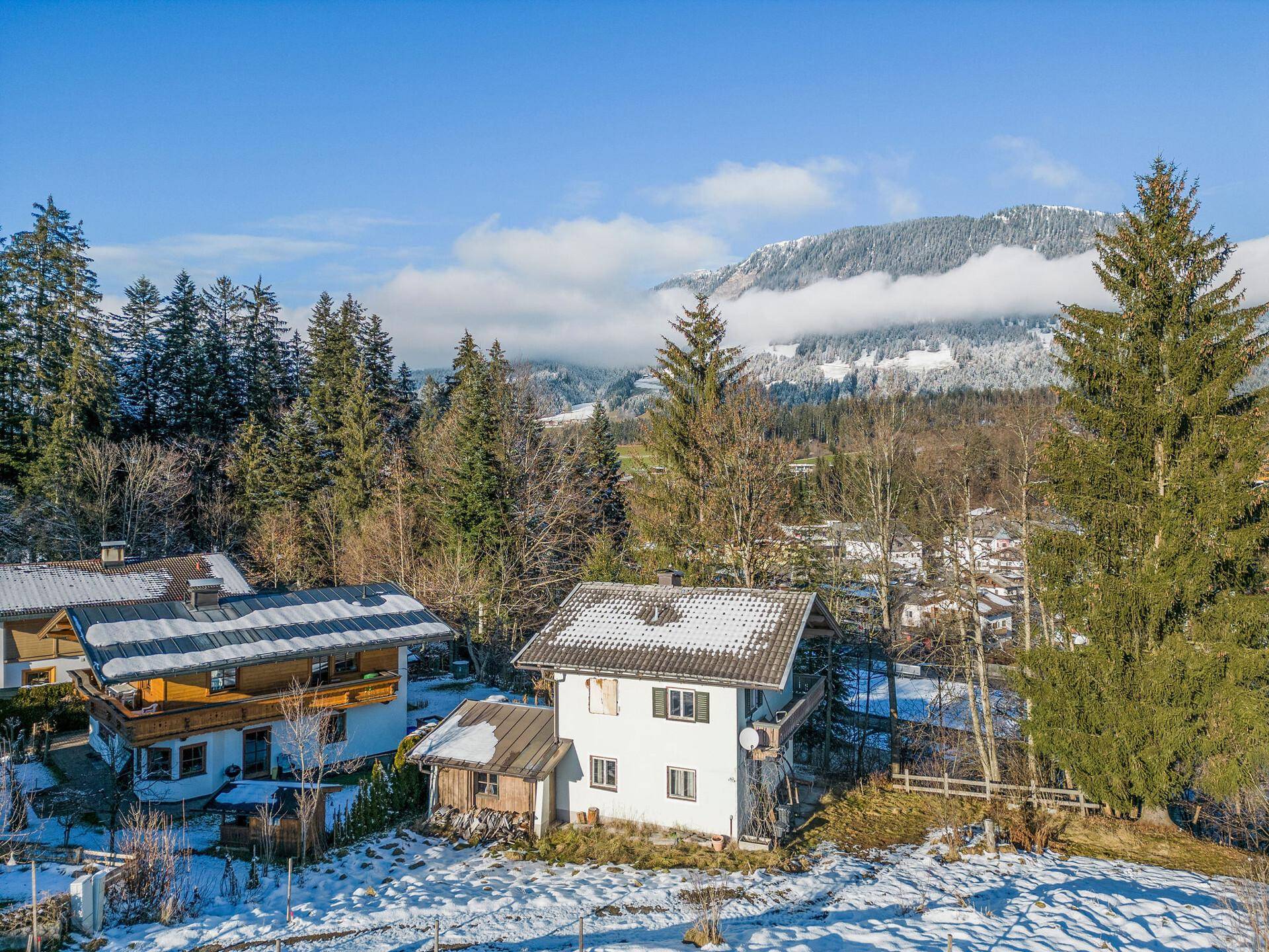 Winterliche Ansicht von traditionellen Häusern in einer schneebedeckten Berglandschaft.
