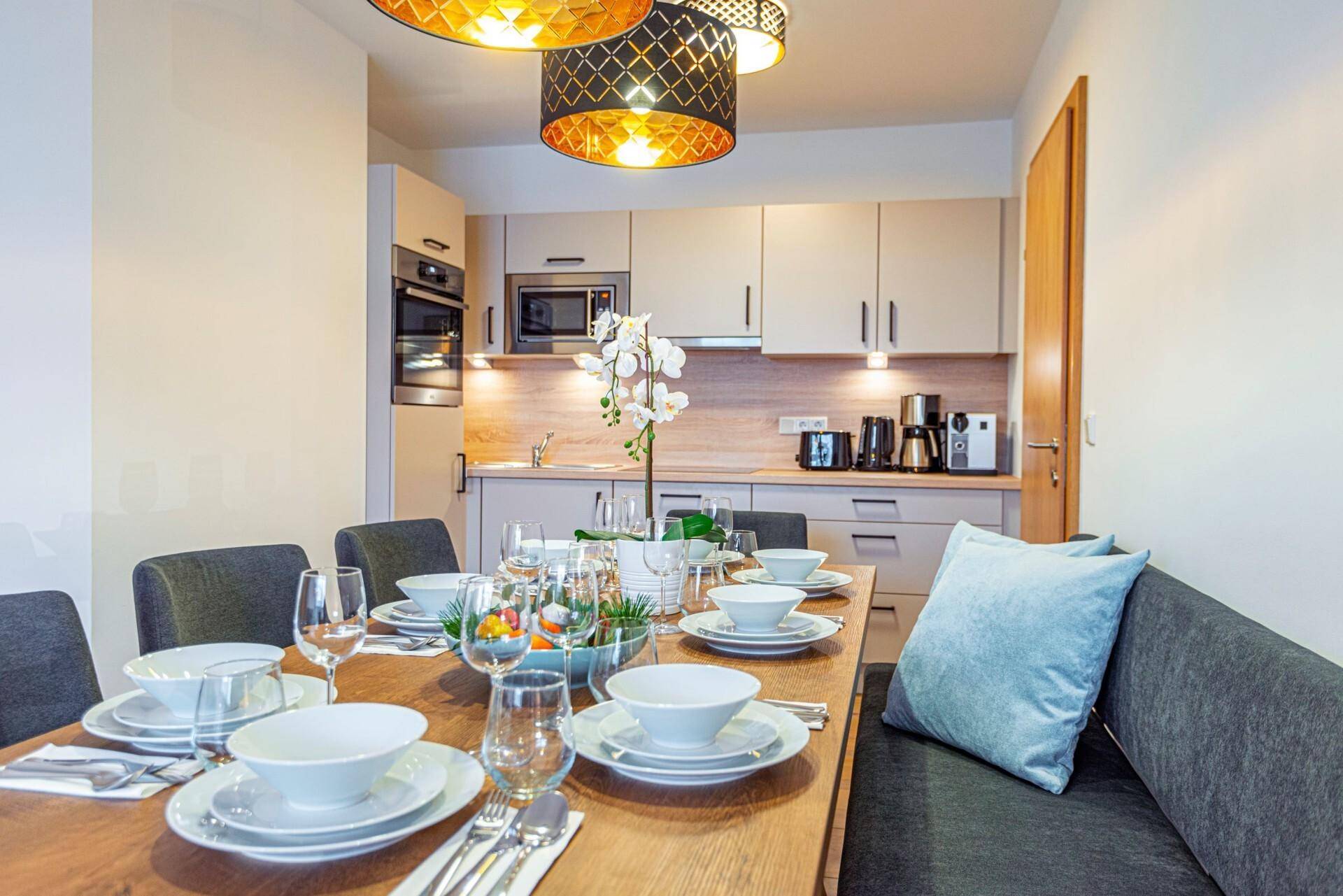 Heller Essbereich mit Holztisch und moderner Einbauküche im Hintergrund, ideal für Mahlzeiten.