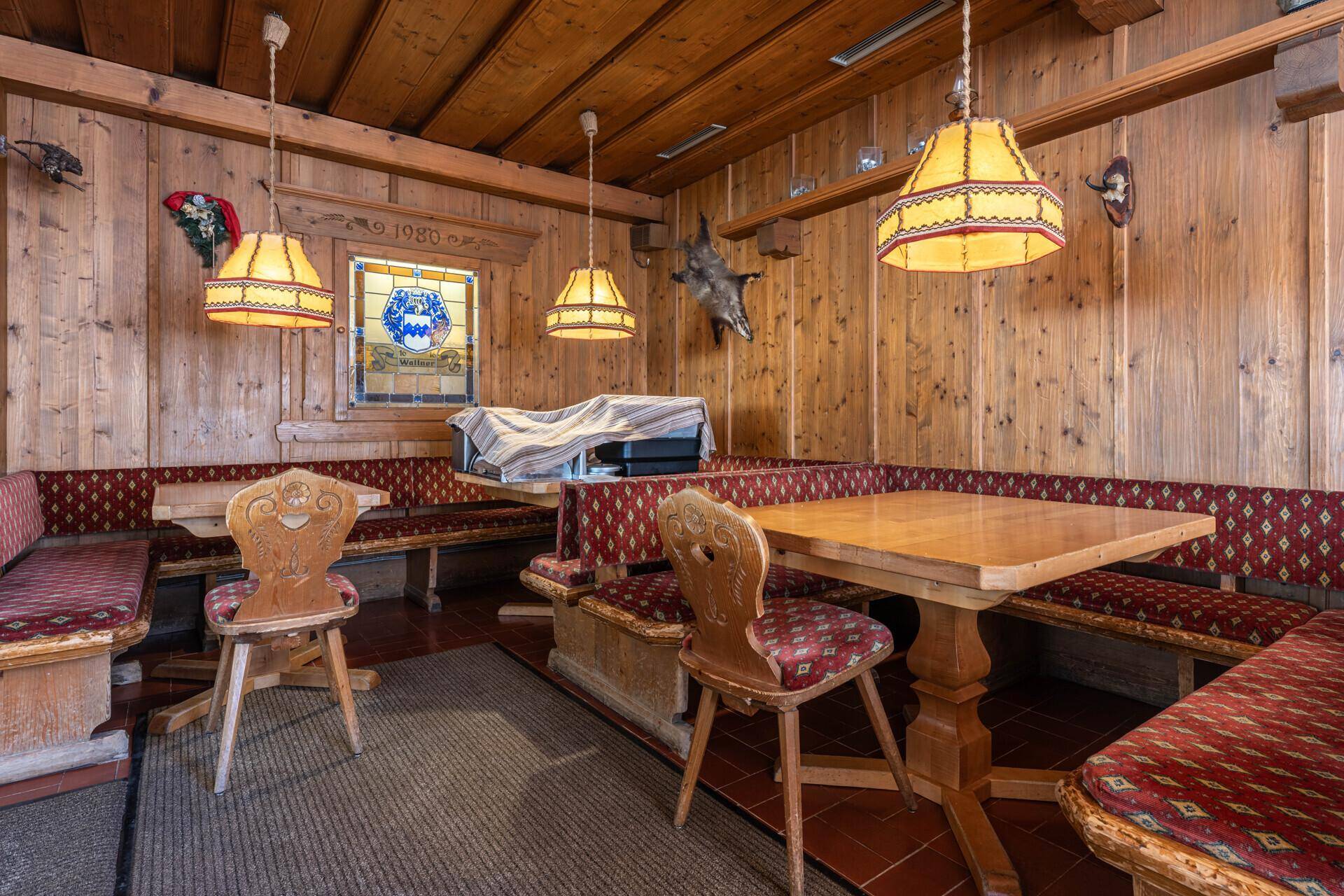 Gemütlicher Essbereich im traditionellen Stil mit viel Holzvertäfelung, Eckbänken und rustikalen Tischen.