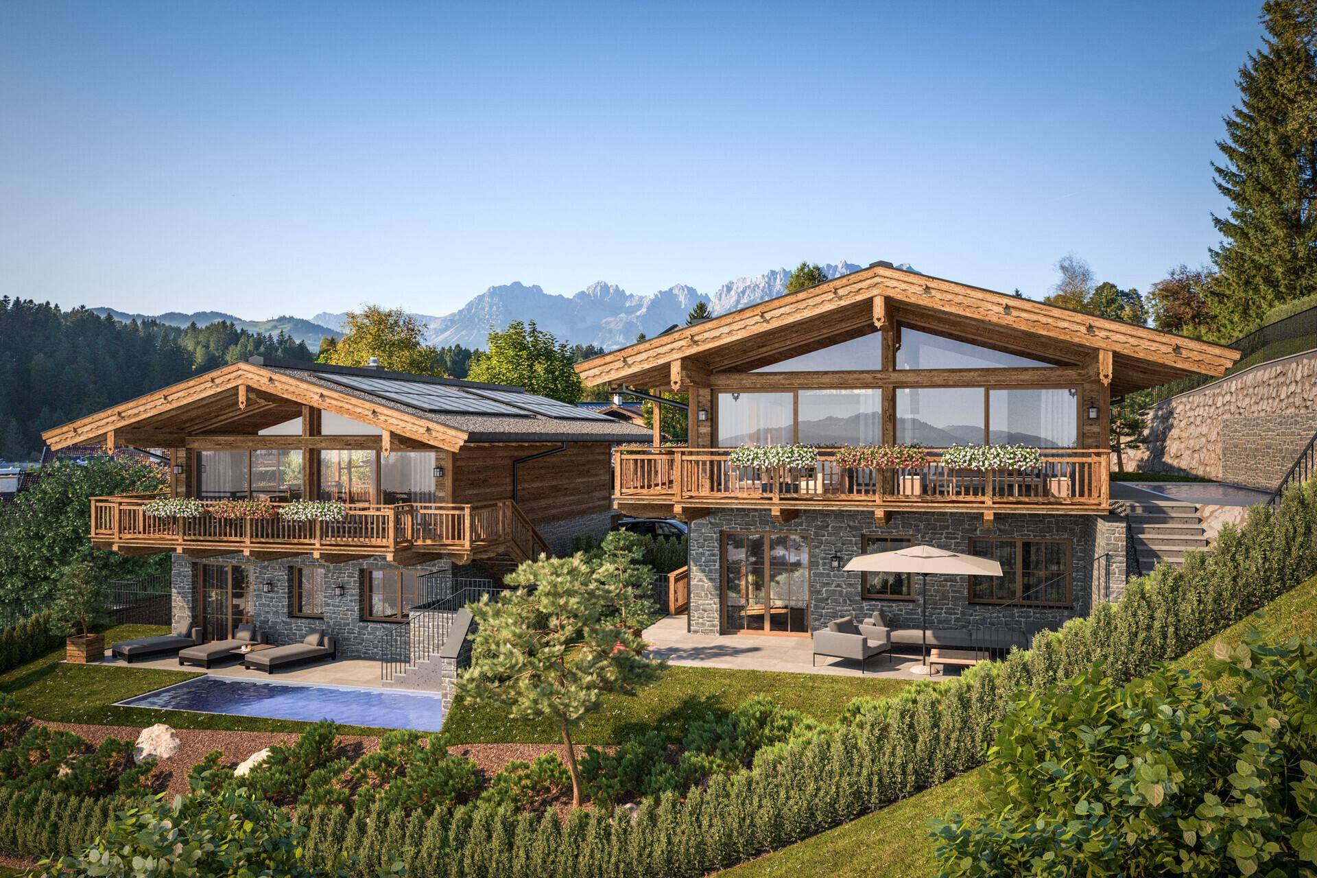 Rückansicht der Chalets mit Balkonen, einem Pool und weitem Blick auf die umliegende Berglandschaft.
