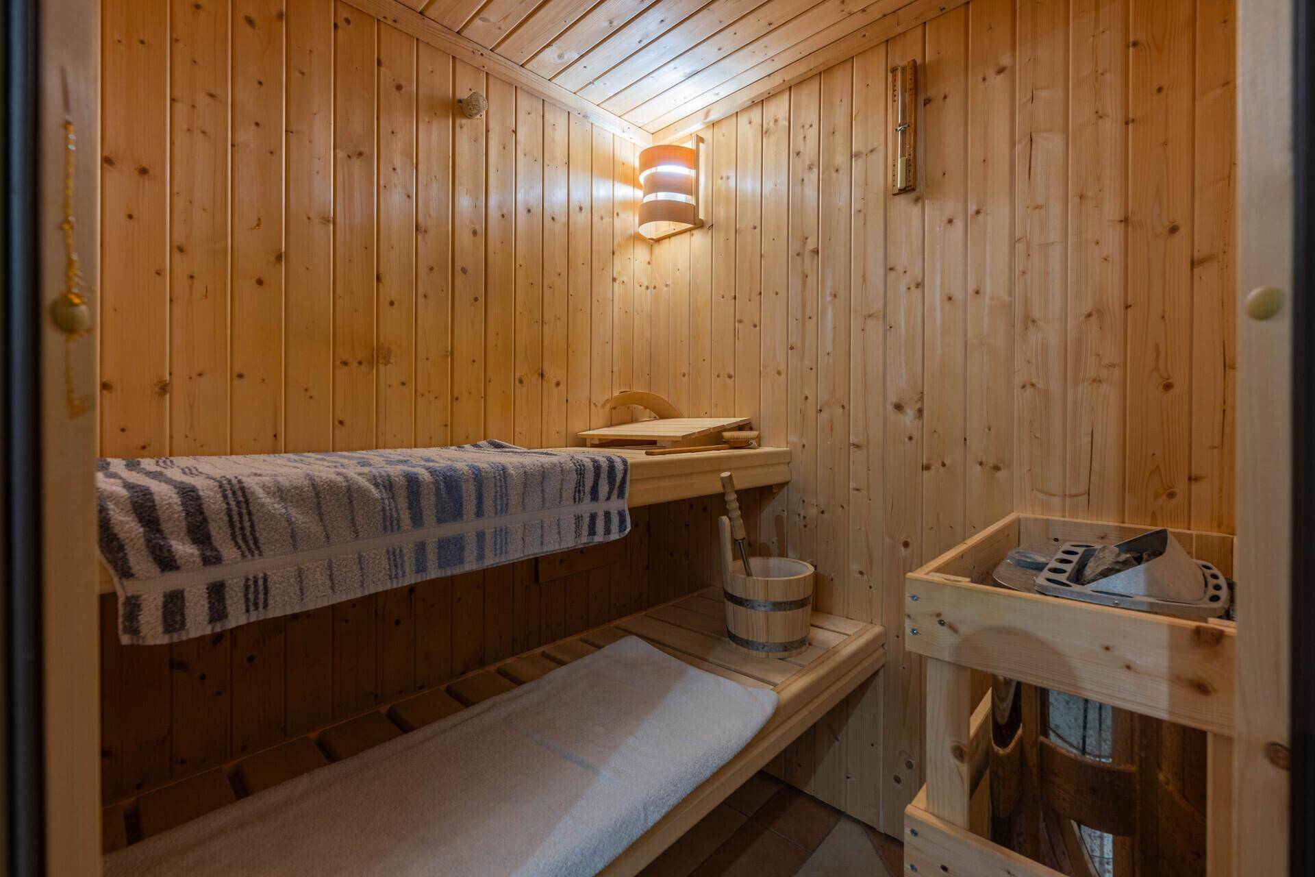 Traditionelle Holzsauna mit Bänken und typischem Zubehör für Entspannung.