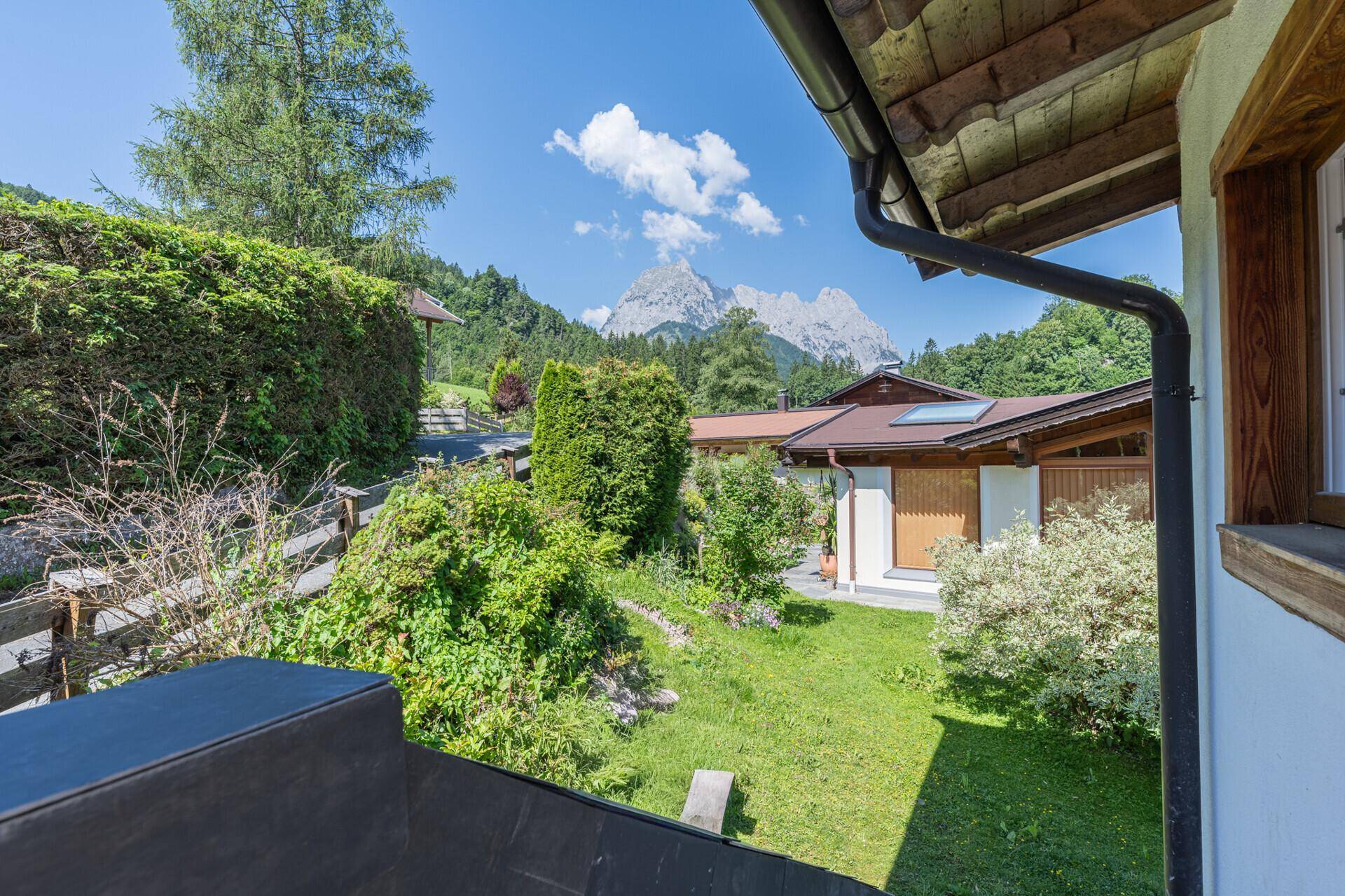 Malerischer Ausblick auf den gepflegten Garten und die umliegende Berglandschaft.