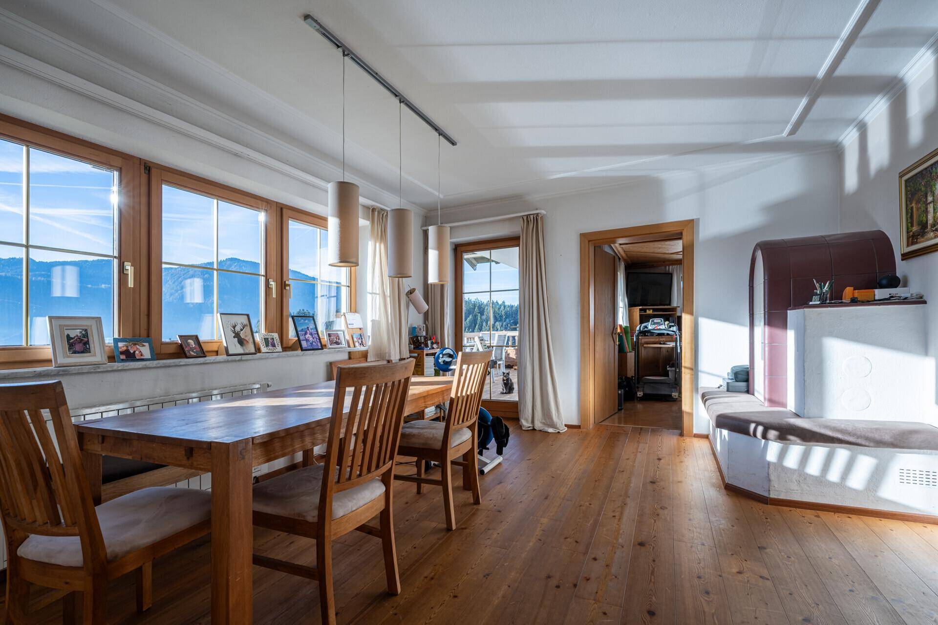 Heller Essbereich mit Holzboden, großem Esstisch und weitem Blick auf die Berge.