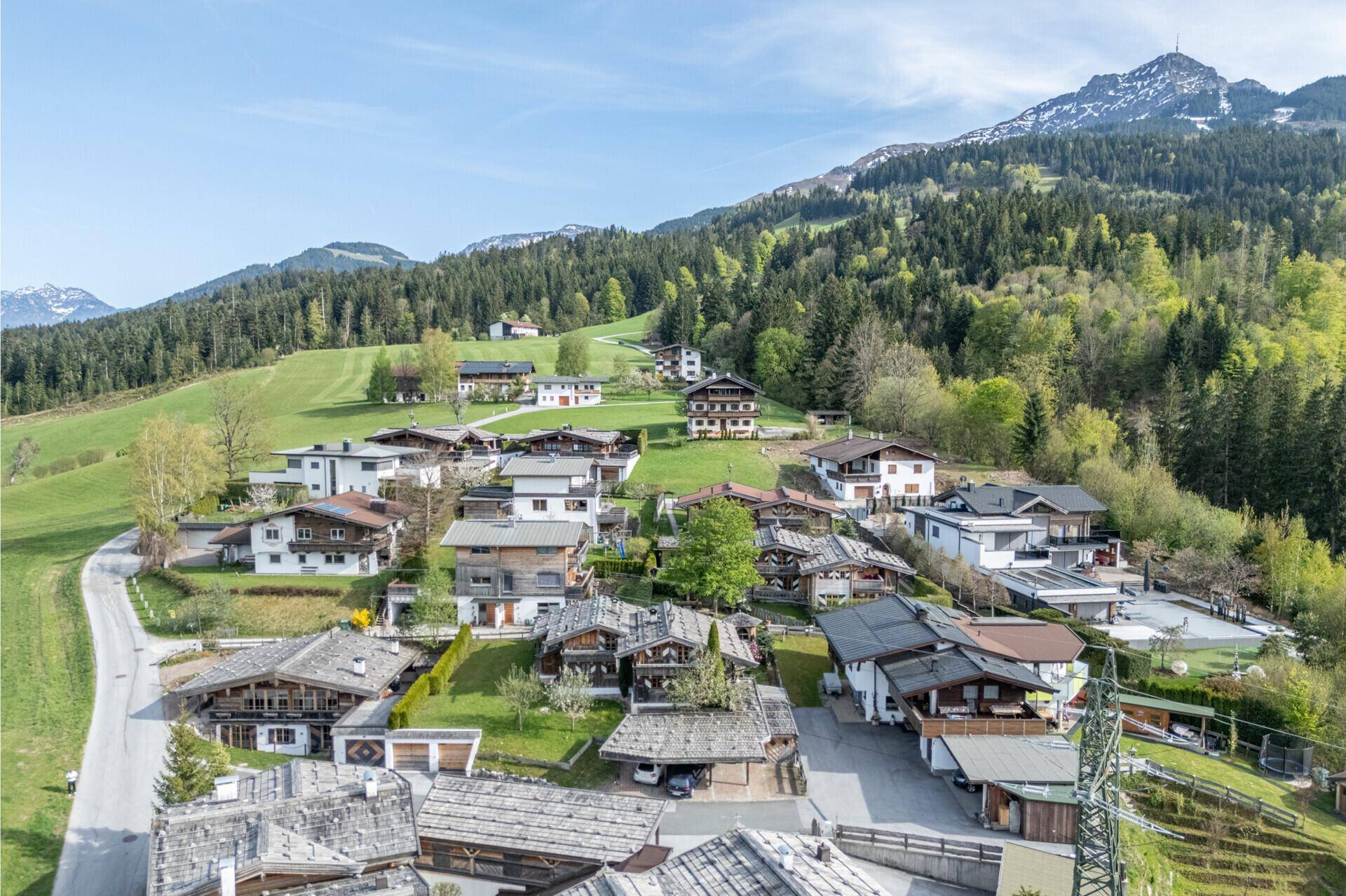 Panoramablick auf ein malerisches Dorf in einer grünen Berglandschaft.