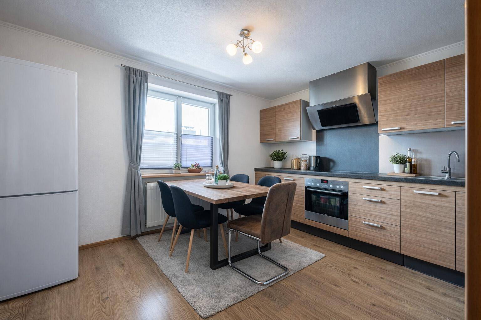 Funktionale Wohnküche mit Holzelementen, Essbereich und modernen Einbaugeräten.