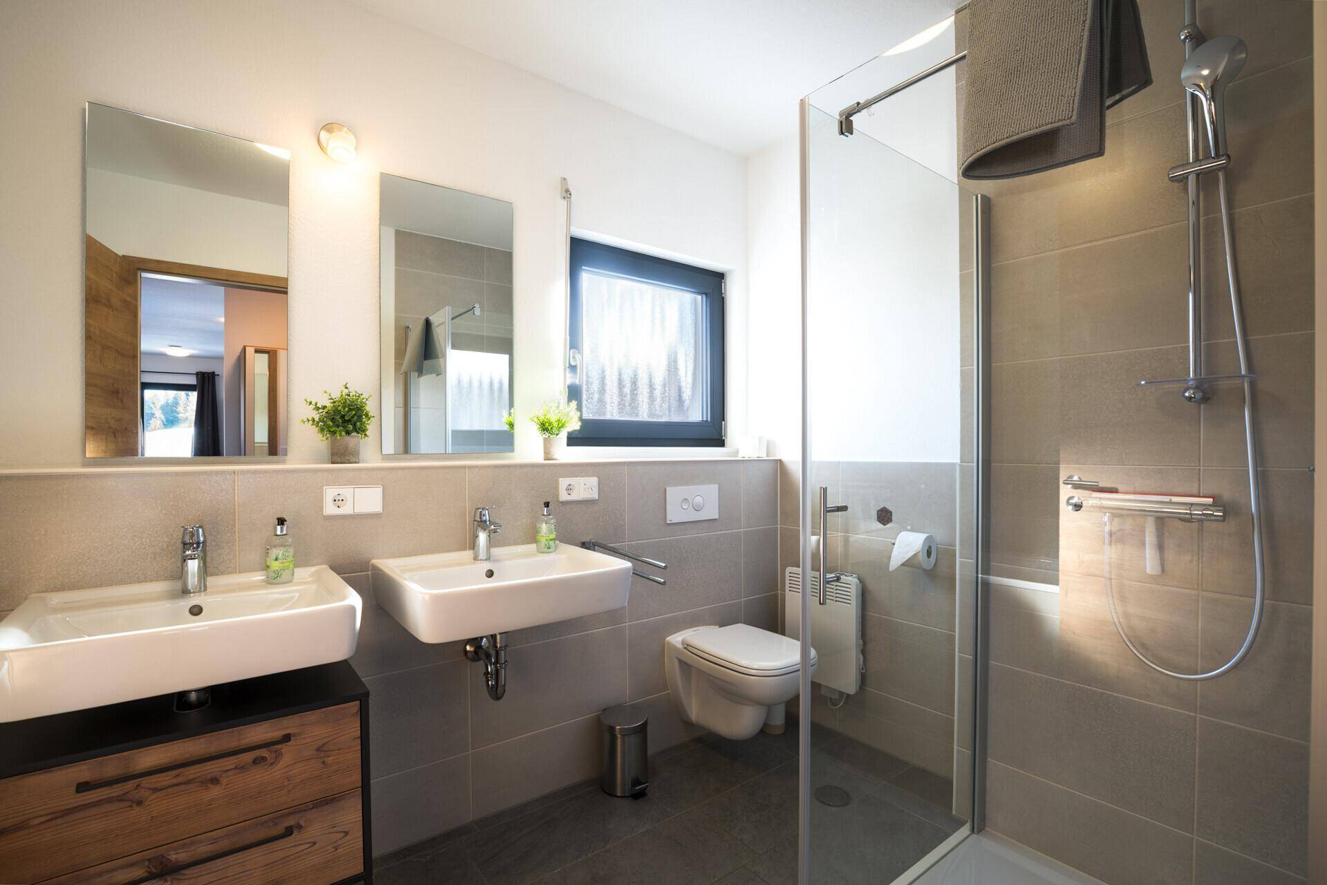 Modernes Badezimmer mit Doppelwaschbecken, ebenerdiger Dusche und Fenster.
